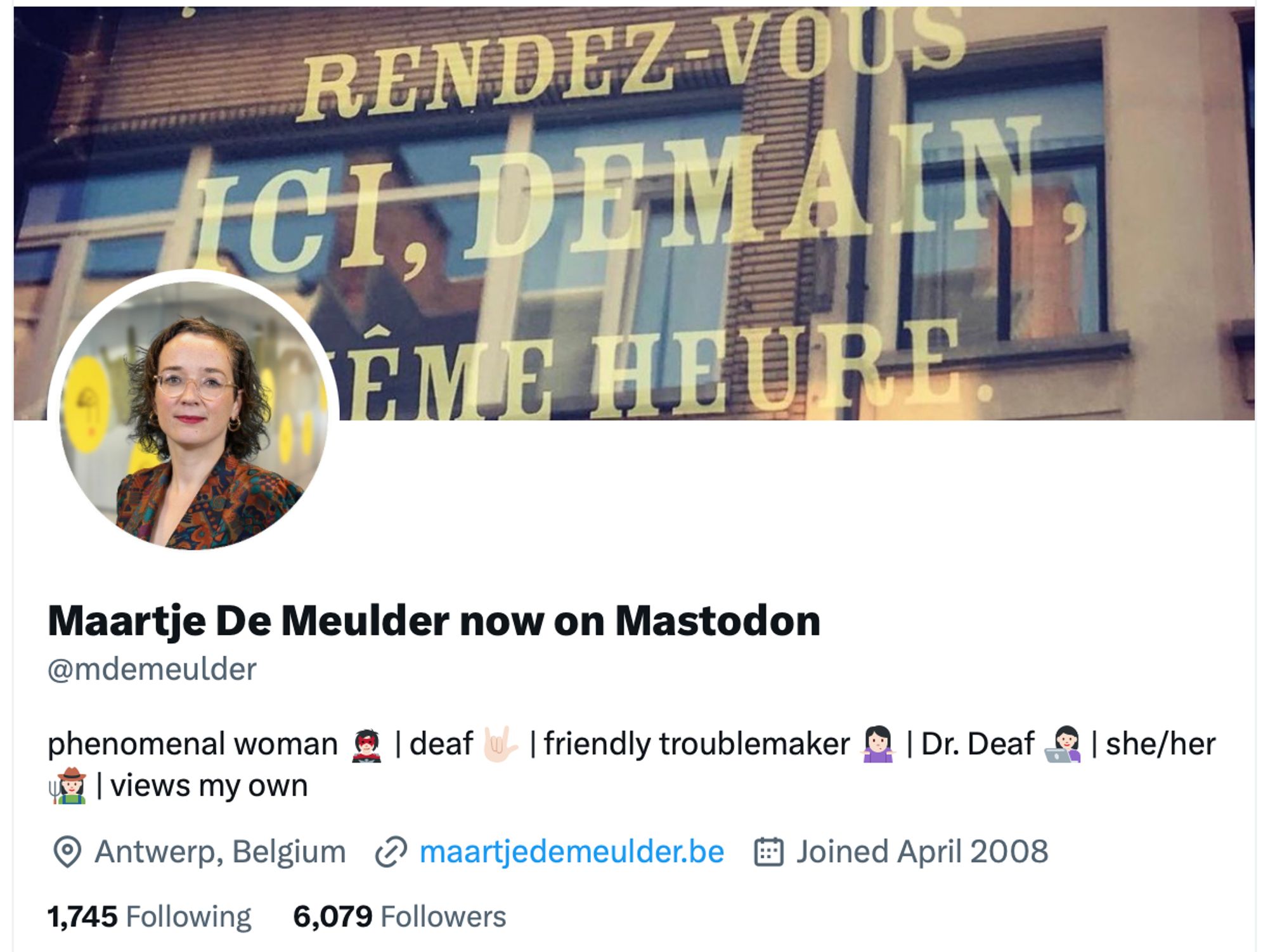 A Twitter profile screenshot for Maartje De Meulder. The profile photo shows a woman with short curly hair, glasses, and a patterned jacket. Her bio reads: "phenomenal woman 👩🏻 | deaf 🤟 | friendly troublemaker 🧑🏻‍💻 | Dr. Deaf 🧑🏻‍🏫 | she/her 🧑🏻‍💻 | views my own". She is located in Antwerp, Belgium, and has 1,745 following and 6,079 followers. The header image behind her profile photo features the text, "RENDEZ-VOUS ICI, DEMAIN, À LA MÊME HEURE."