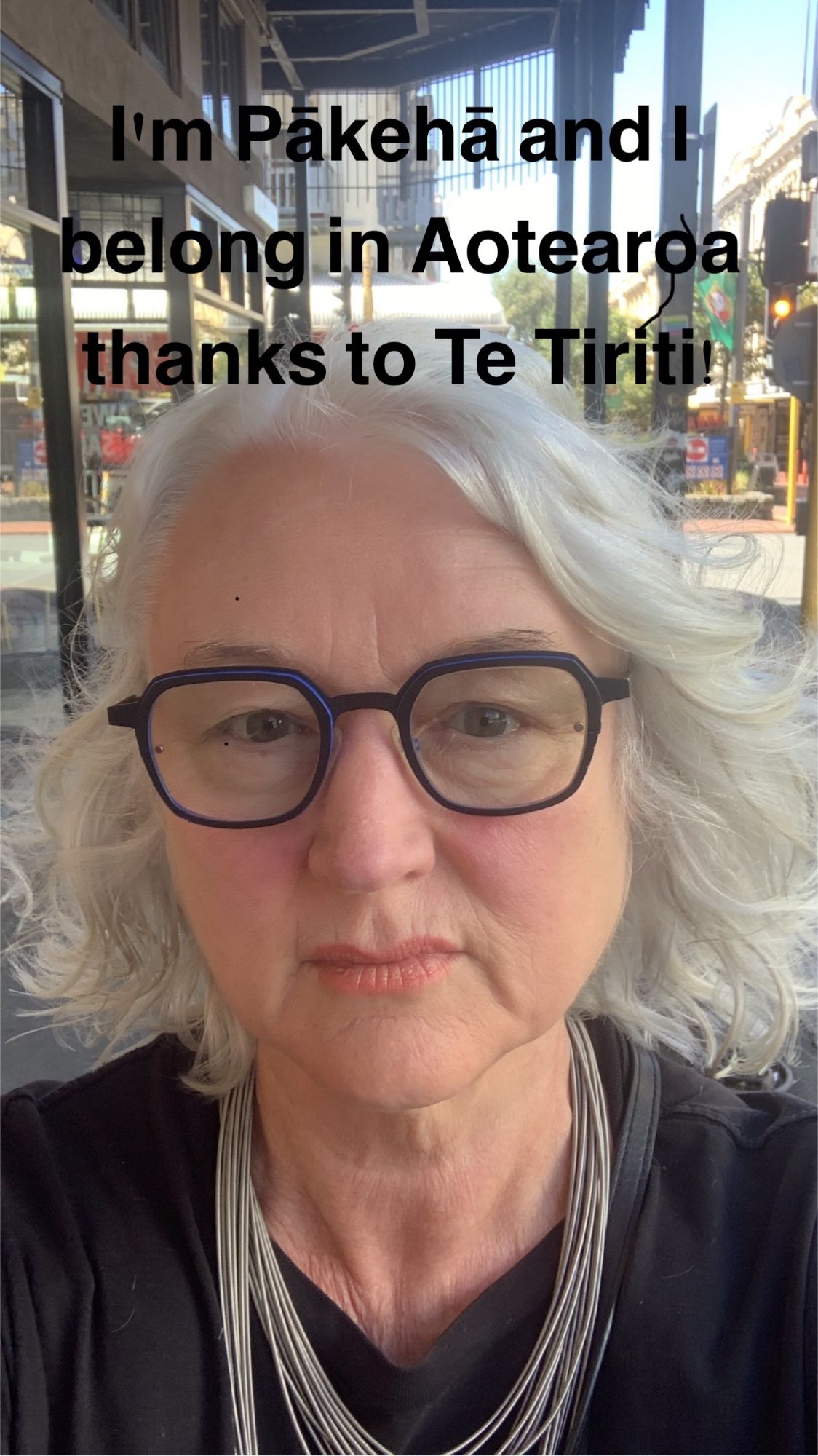 Picture of me wearing black with glasses, white hair and strand necklace. Text says I'm Pākehā and I belong in Aotearoa thanks to Te Tiriti!