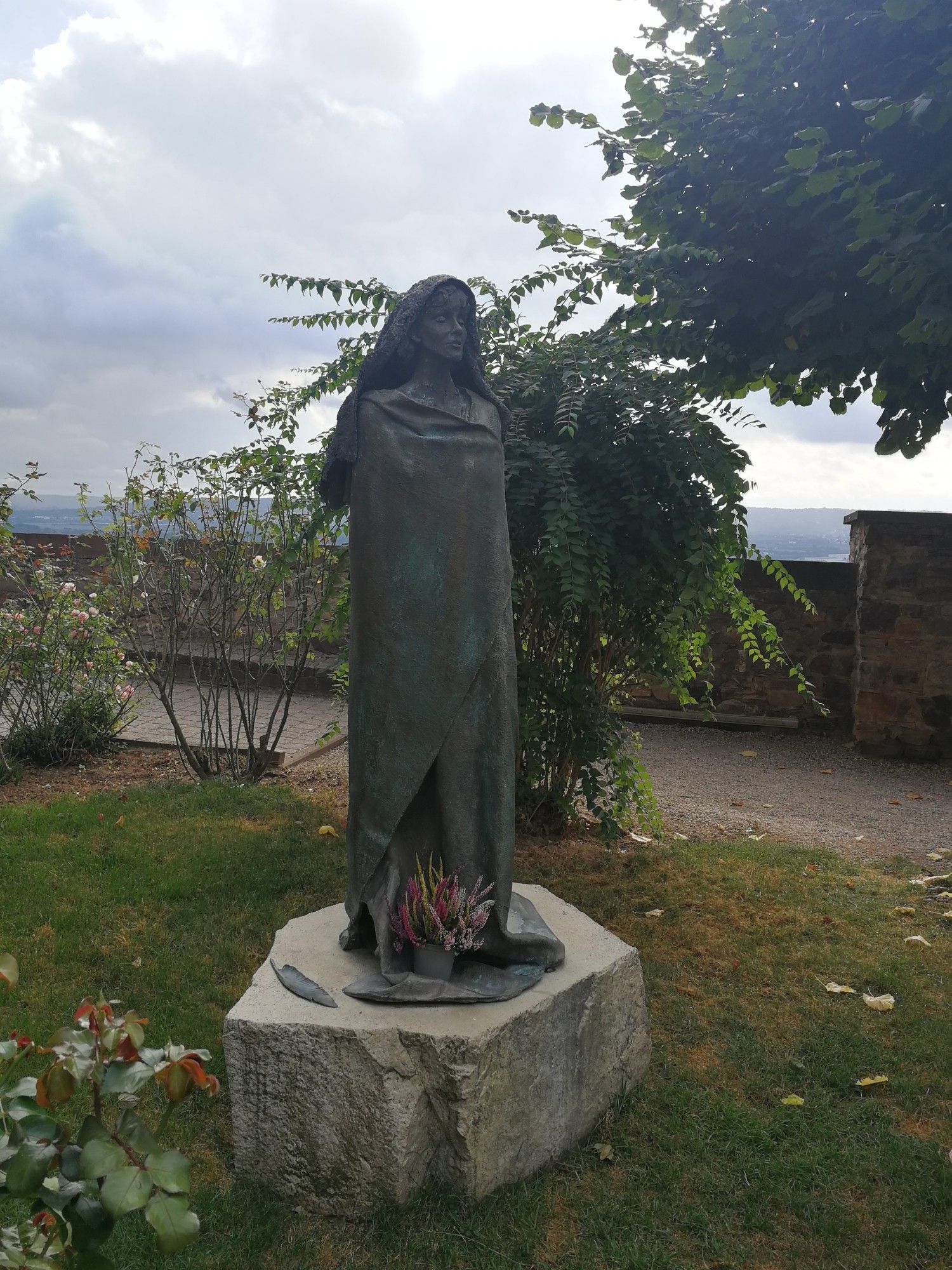 Skulptur von Hildegard im Garten vor der Kirche