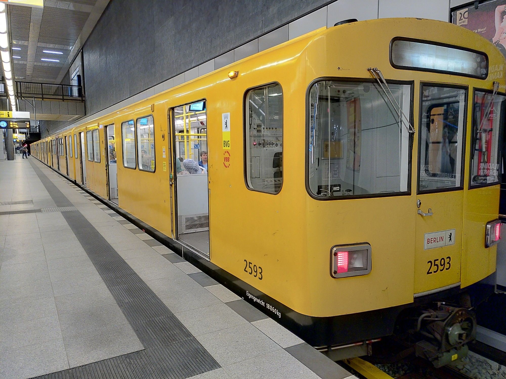 A yellow, empty Berlin subway train at an empty platform, doors open, everyone has already departed to Berlin central station.