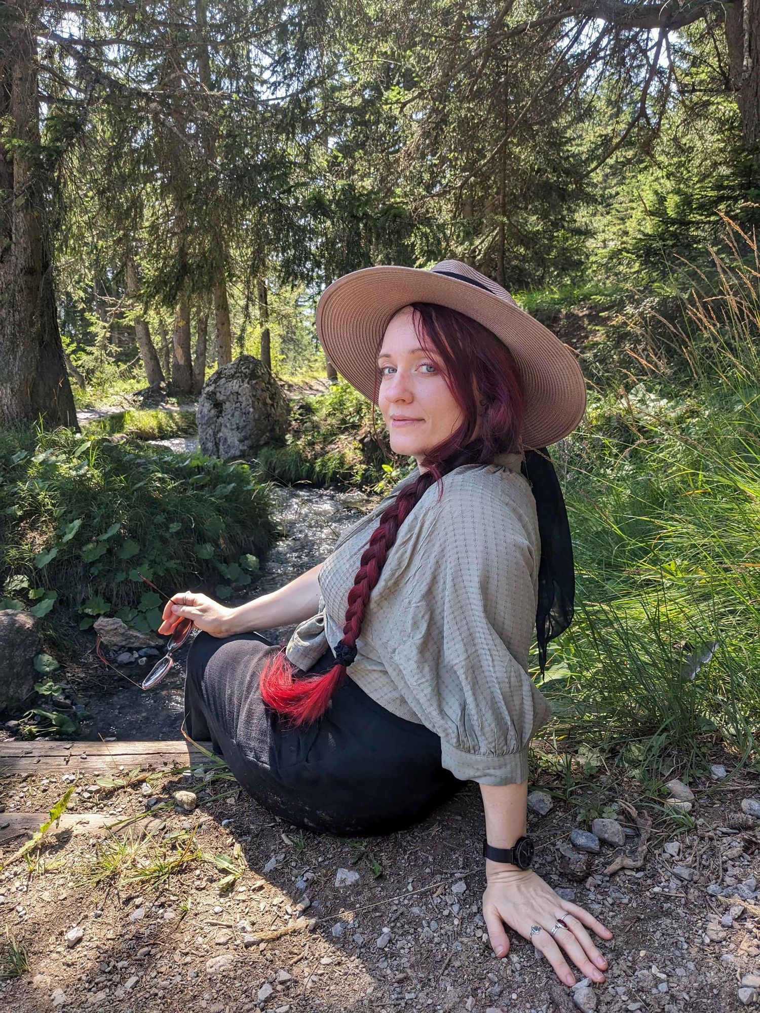 Photo of me sitting by a picturesque swiss mountain creek.