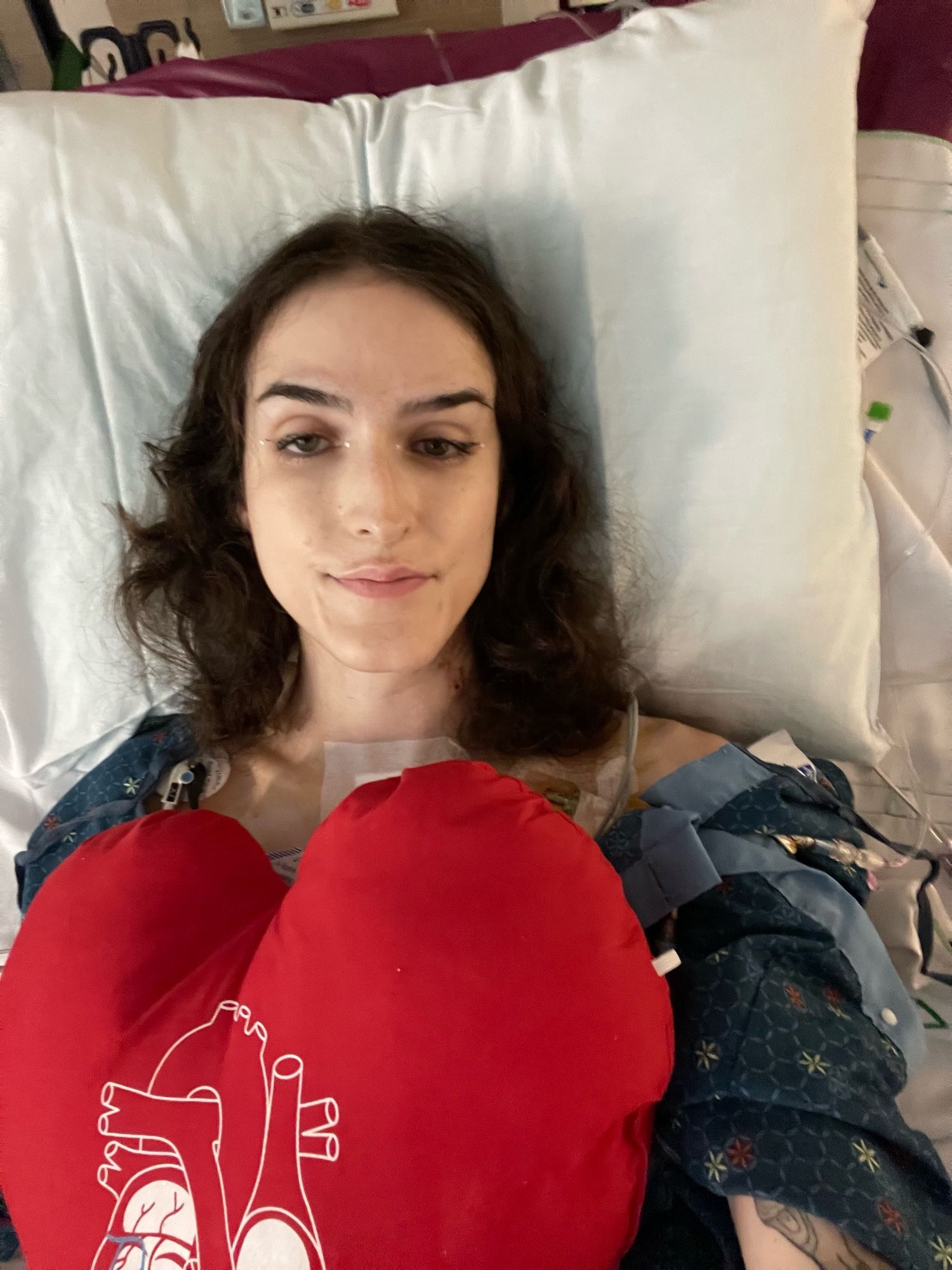 me on a hospital bed with a red heart pillow