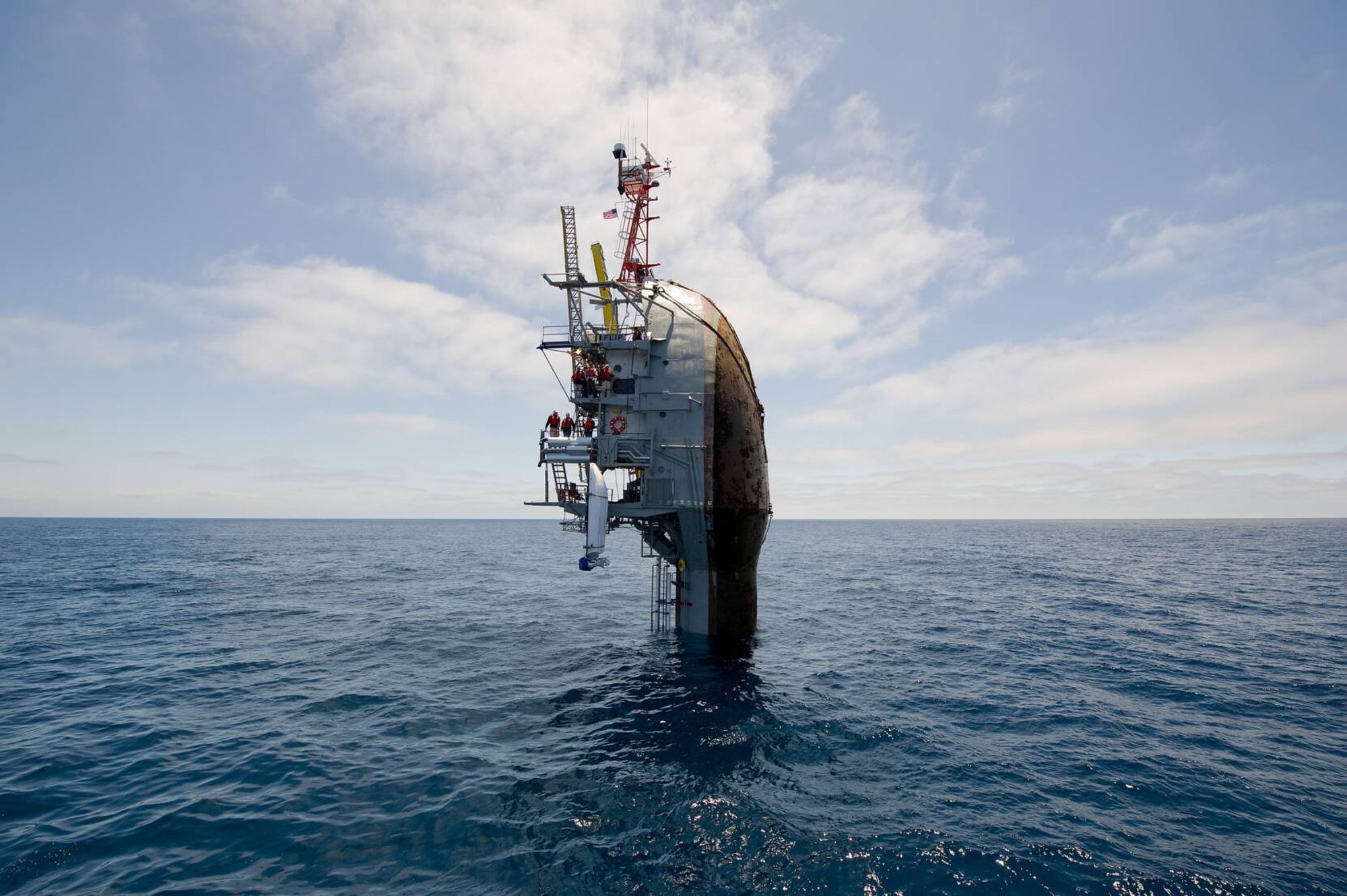 La poupe d'un bateau, à la verticale dans la mer, comme si le navire coulait.