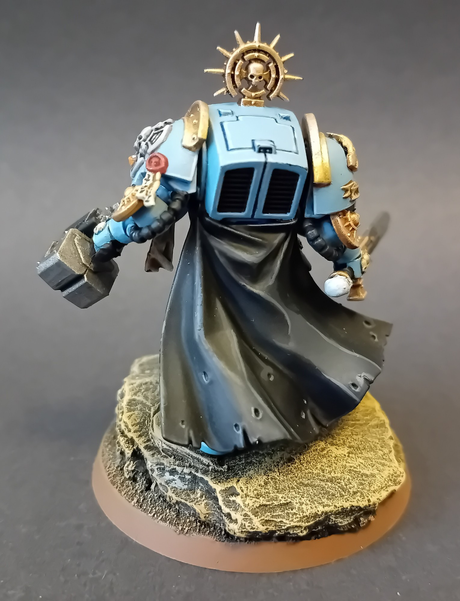 Female Space Marines, Azure Raptors Terminator Captain.
Rear view. Black cloak billowing, contrasting the pale blue armour.