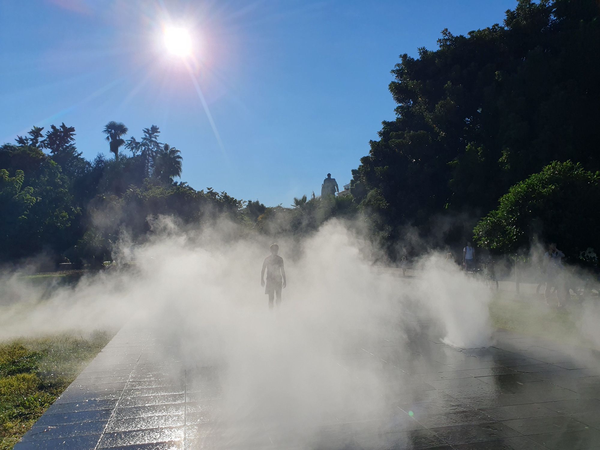 Figure in water feature mist in central Nice