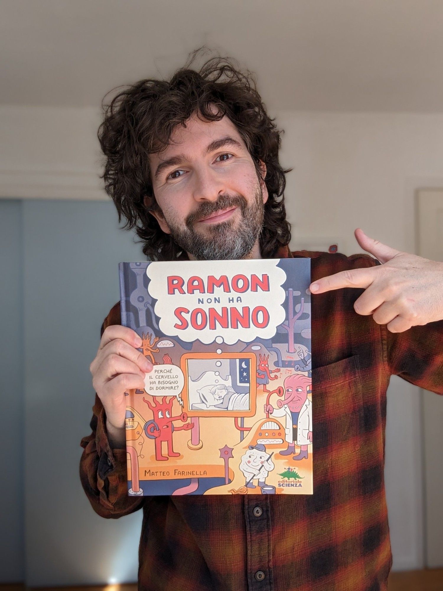 Portrait of Matteo Farinella, holding the children book titled 'Ramon Non Ha Sonno' - Ramon Can't Sleep