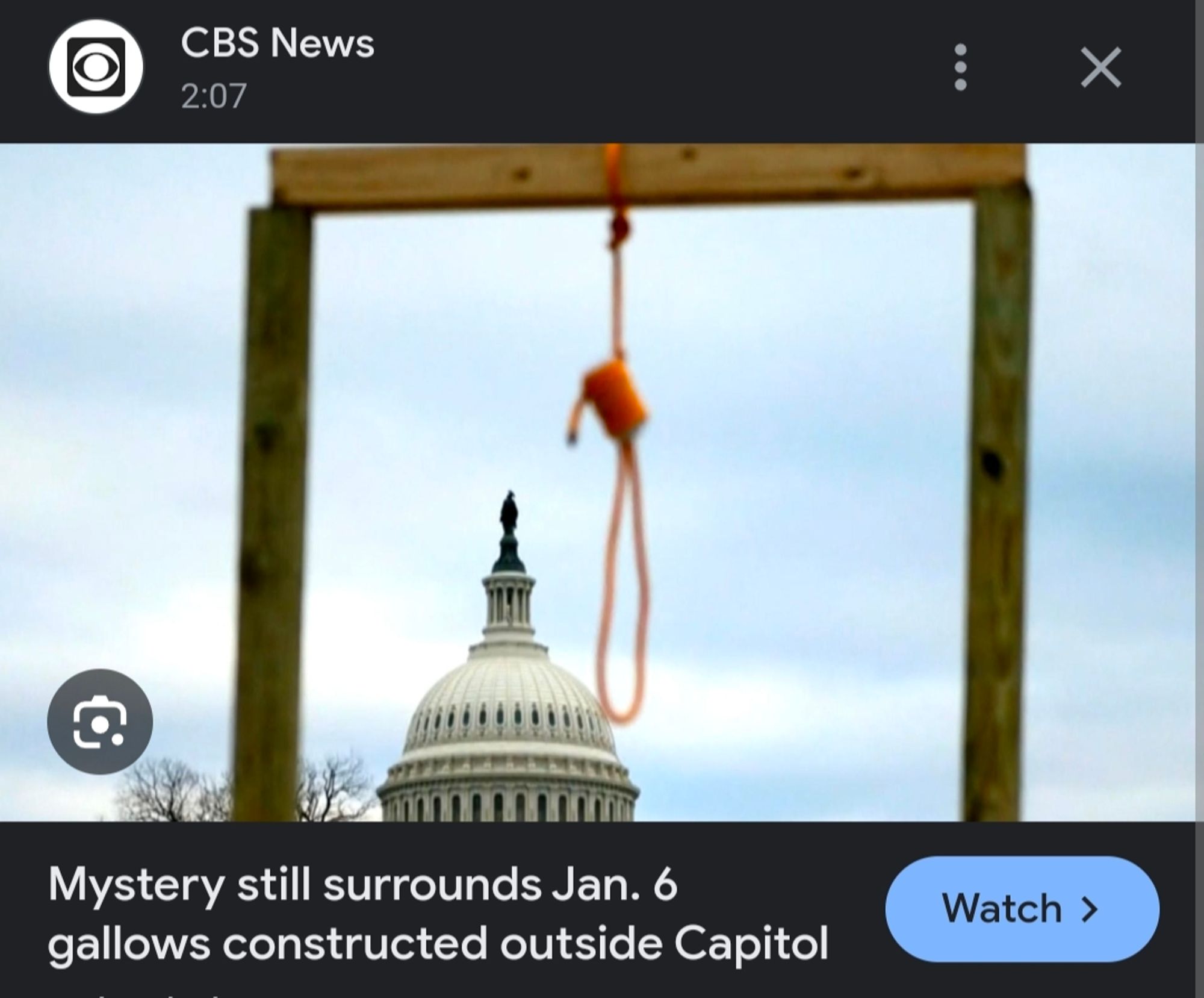 An actual hallows with a noise hanging from it in front of the capital per CBS News reading mystery still surrounds Jan 6 gallows constructed outside capitol