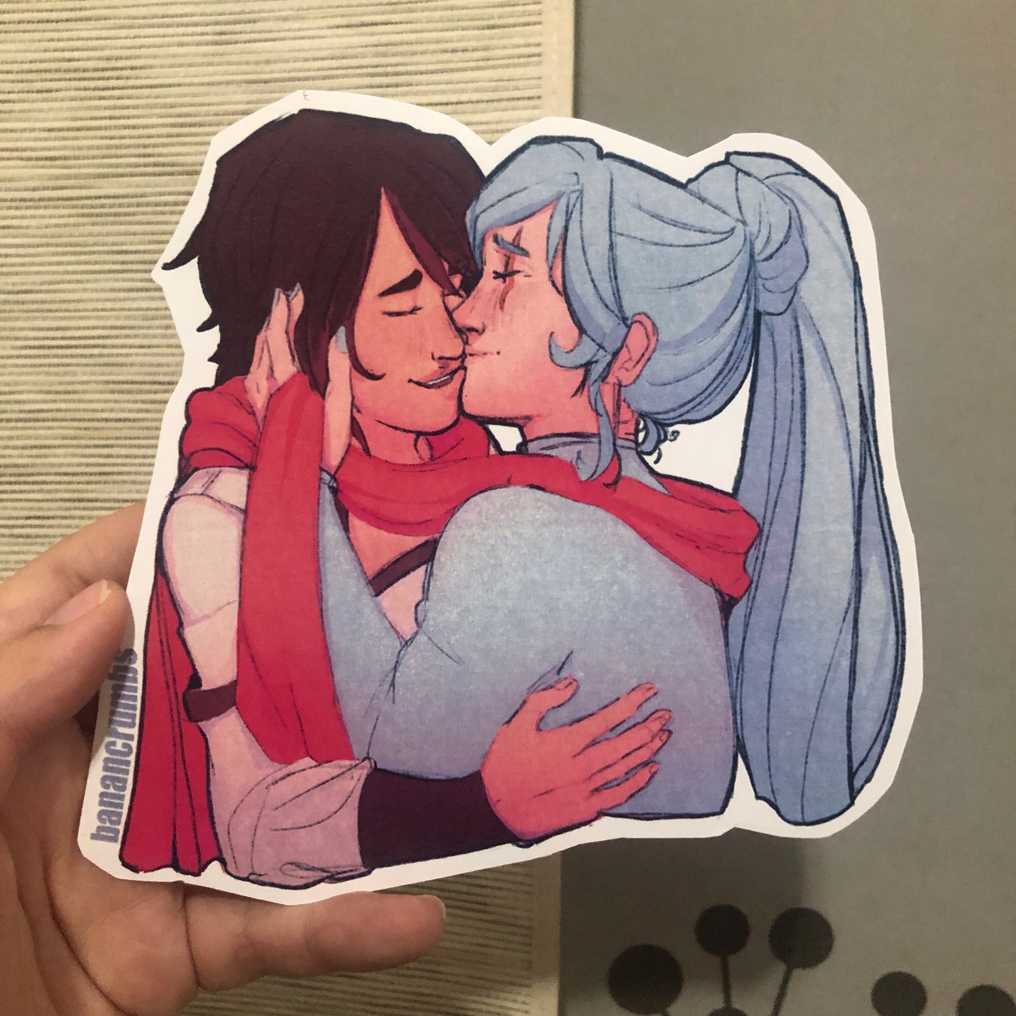 um desenho impresso e recortado das personagens ruby rose e weiss schnee, de rwby! elas estão abraçadas e se beijando, as duas felizes