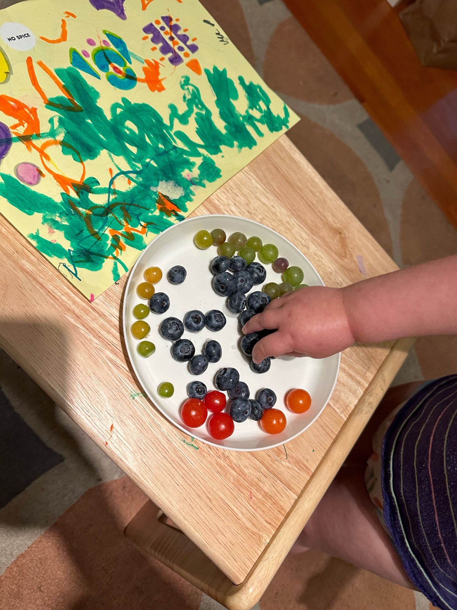 A small hand eating round fruits