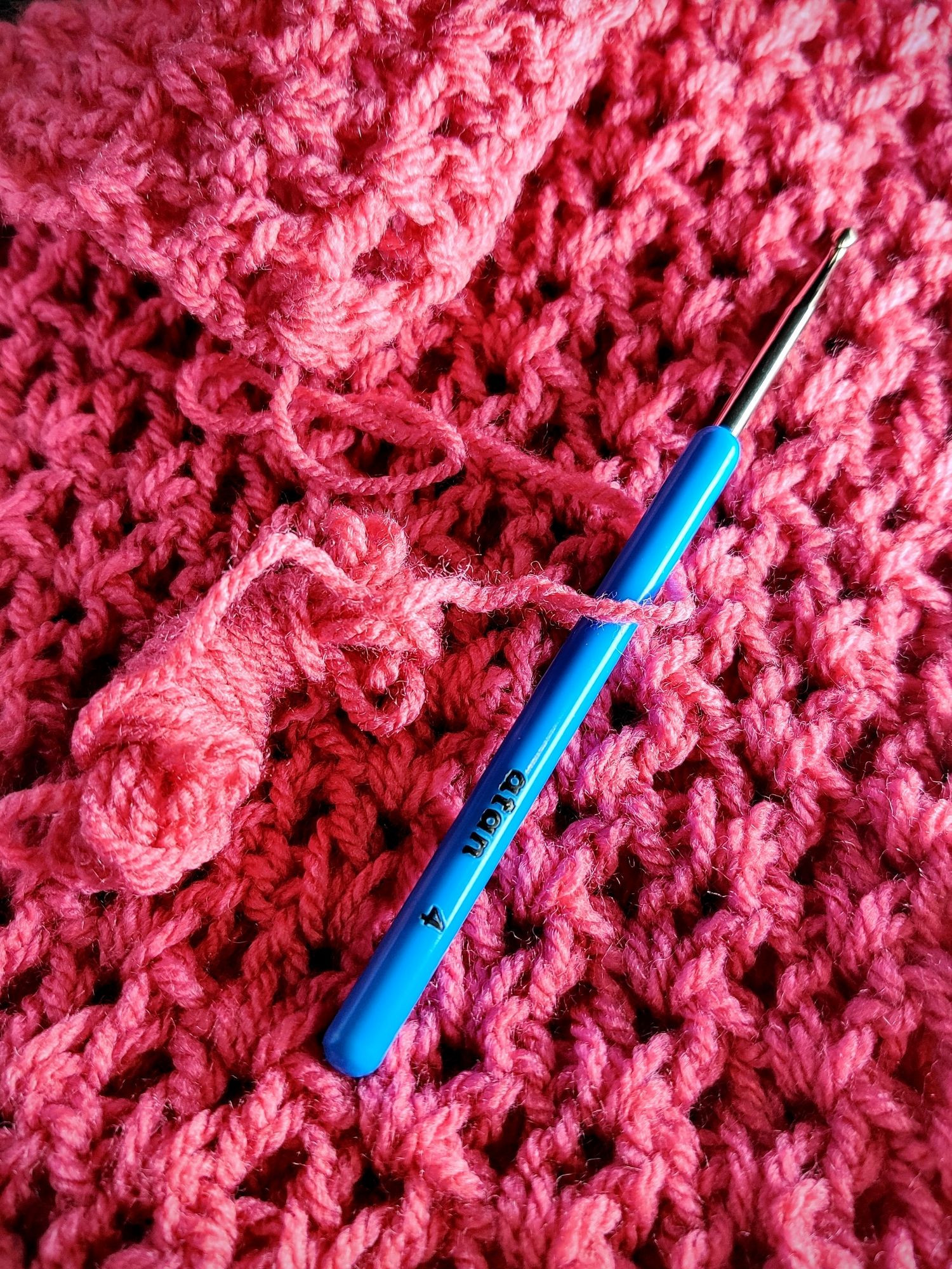 Plein cadre virgule une grande pièce de crochet rose avec un motif ajouré simple et répétitif qui donne une impression de grosse côtes vue de loin. Pour l'échelle, le crochet vintage dont je me sers, de 4 mm, de marque atan. (J'aime énormément le matériel vintage en général très agréable à utiliser, léger solide et qui ne coûte rien). Sur le tissu, on voit le petit peloton de 2 m qui reste après la fin du carré, c'est vraiment pile-poil. #win