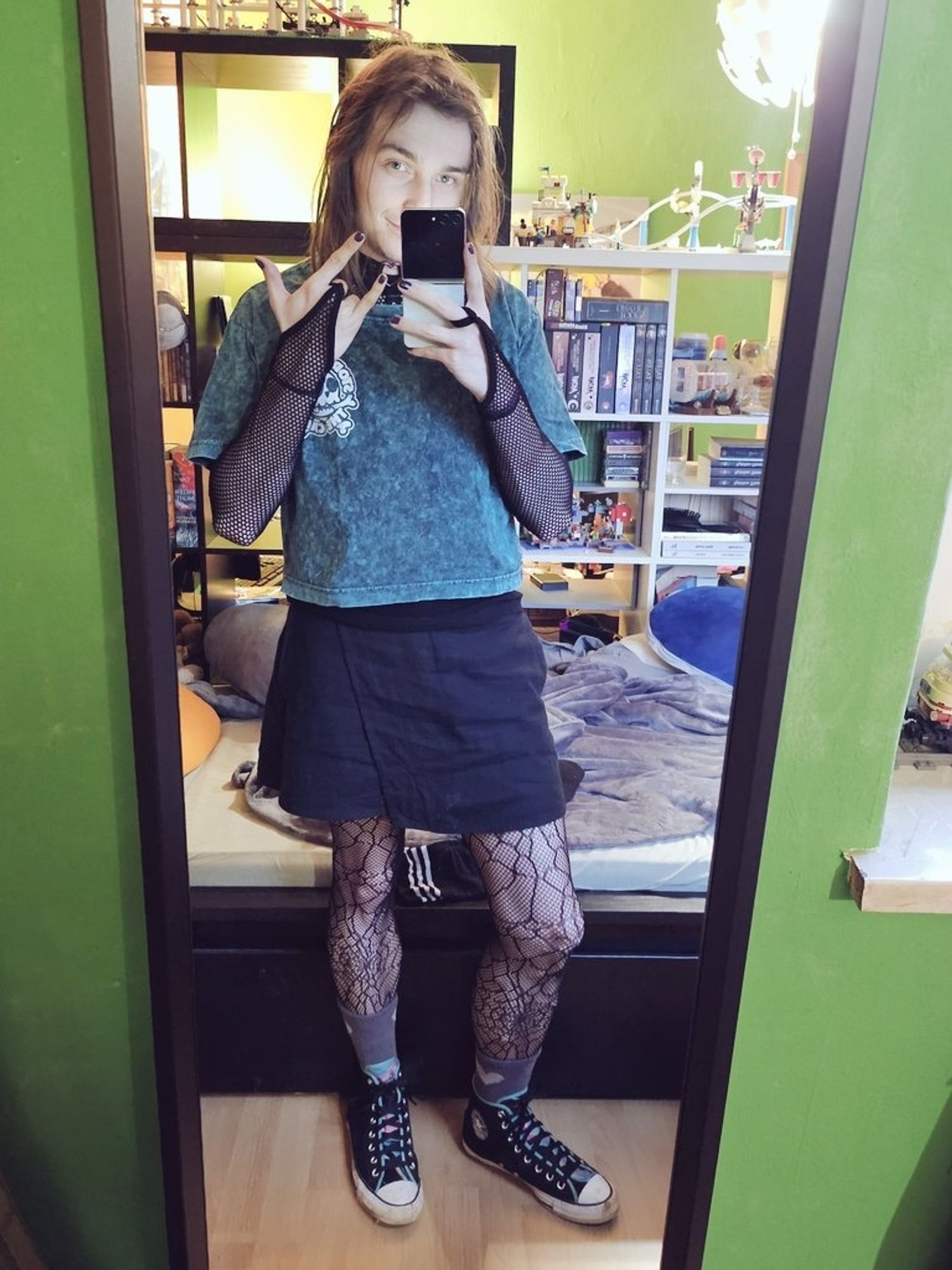 Spiegelselfie.

Schwarze Chucks mit türkis/magenta akzenten, graue Plüschsocken mit beigem Herz, Strumpfhose mit Spinnennetz, schwarzer Rock, Türkises Croptop über Netzoberteil.