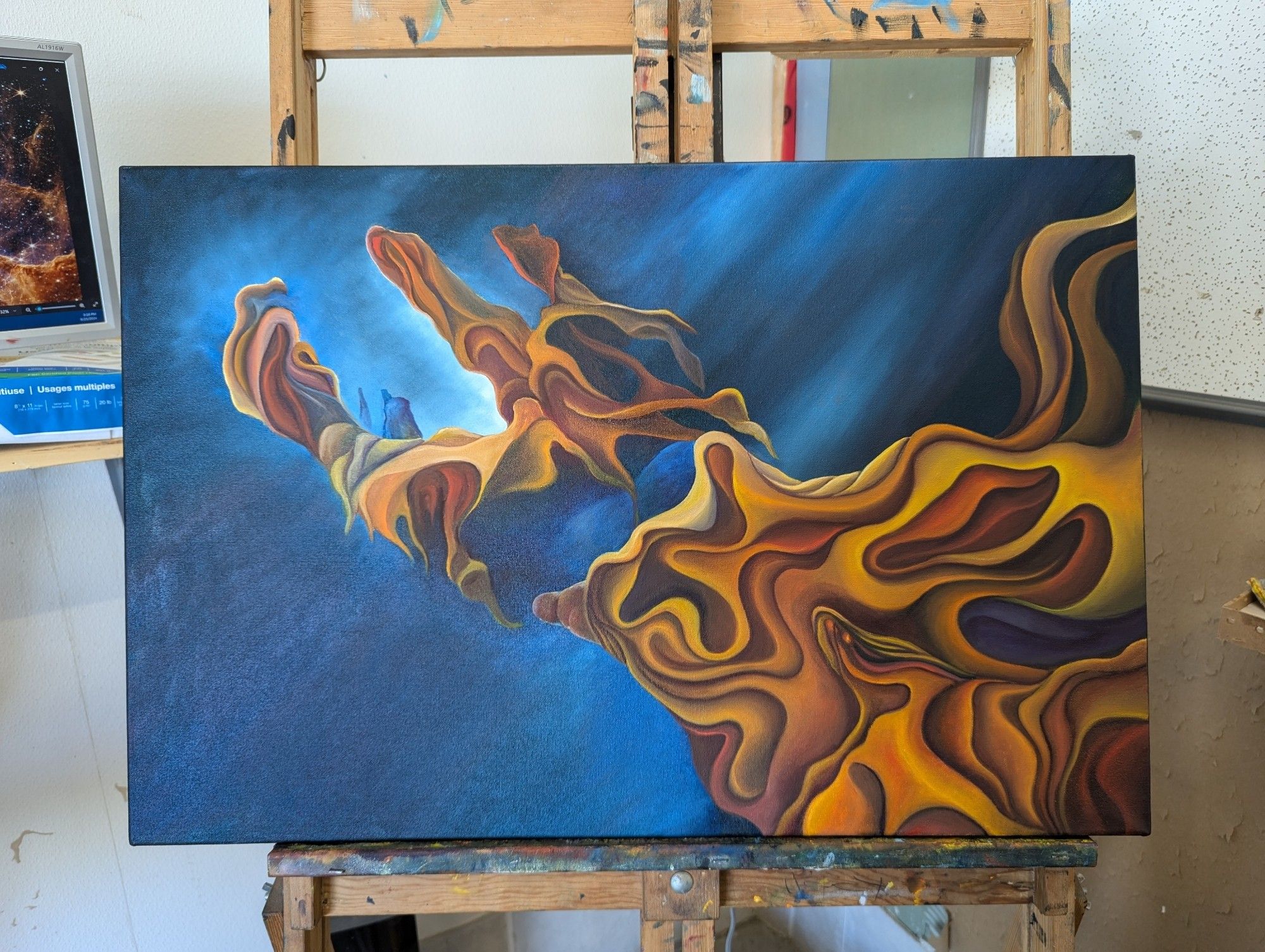 WIP painting of a nebula that looks like a hand with orange yellow clouds on a blue black field