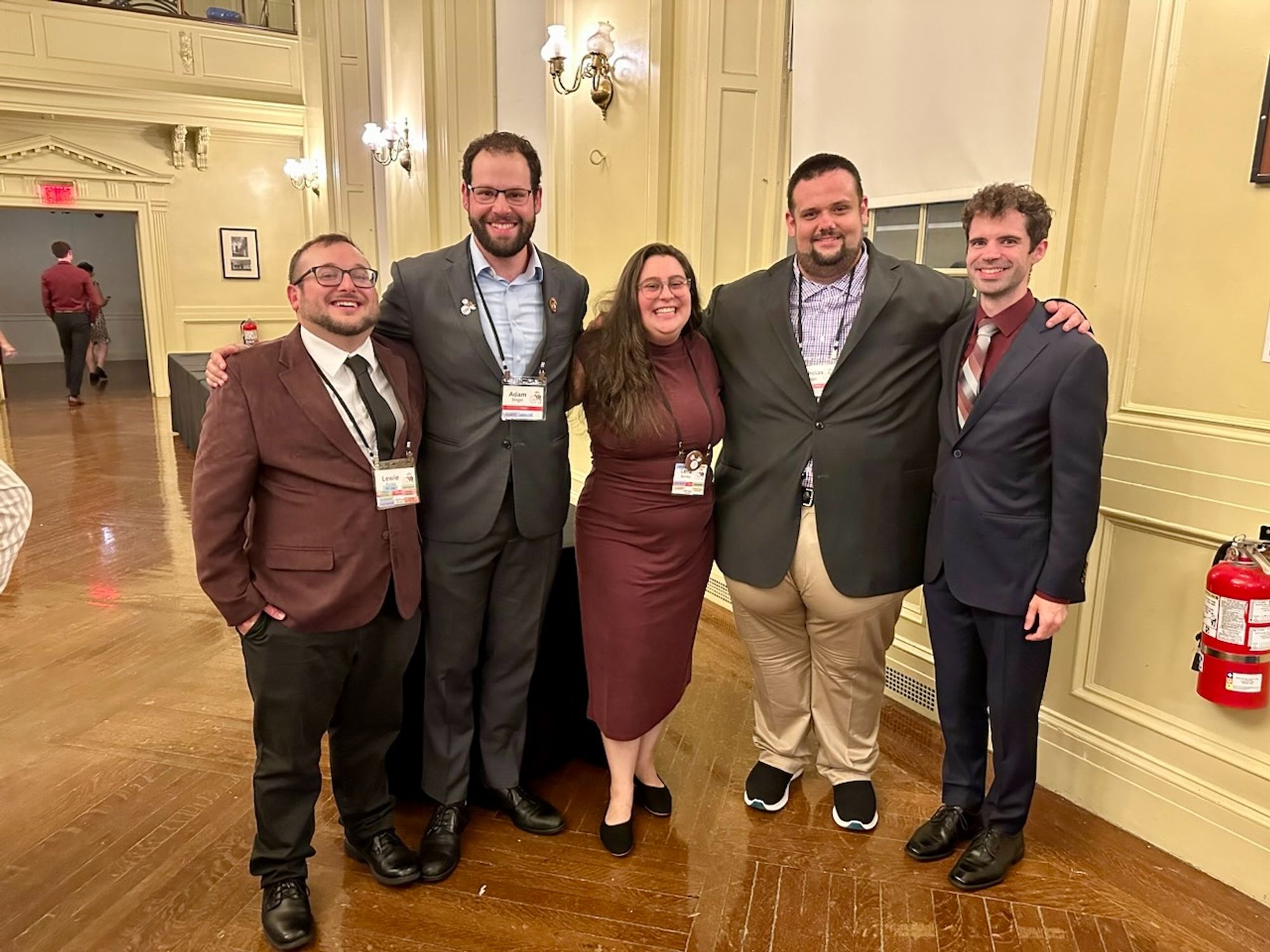 Five people in formalwear pose for the camera