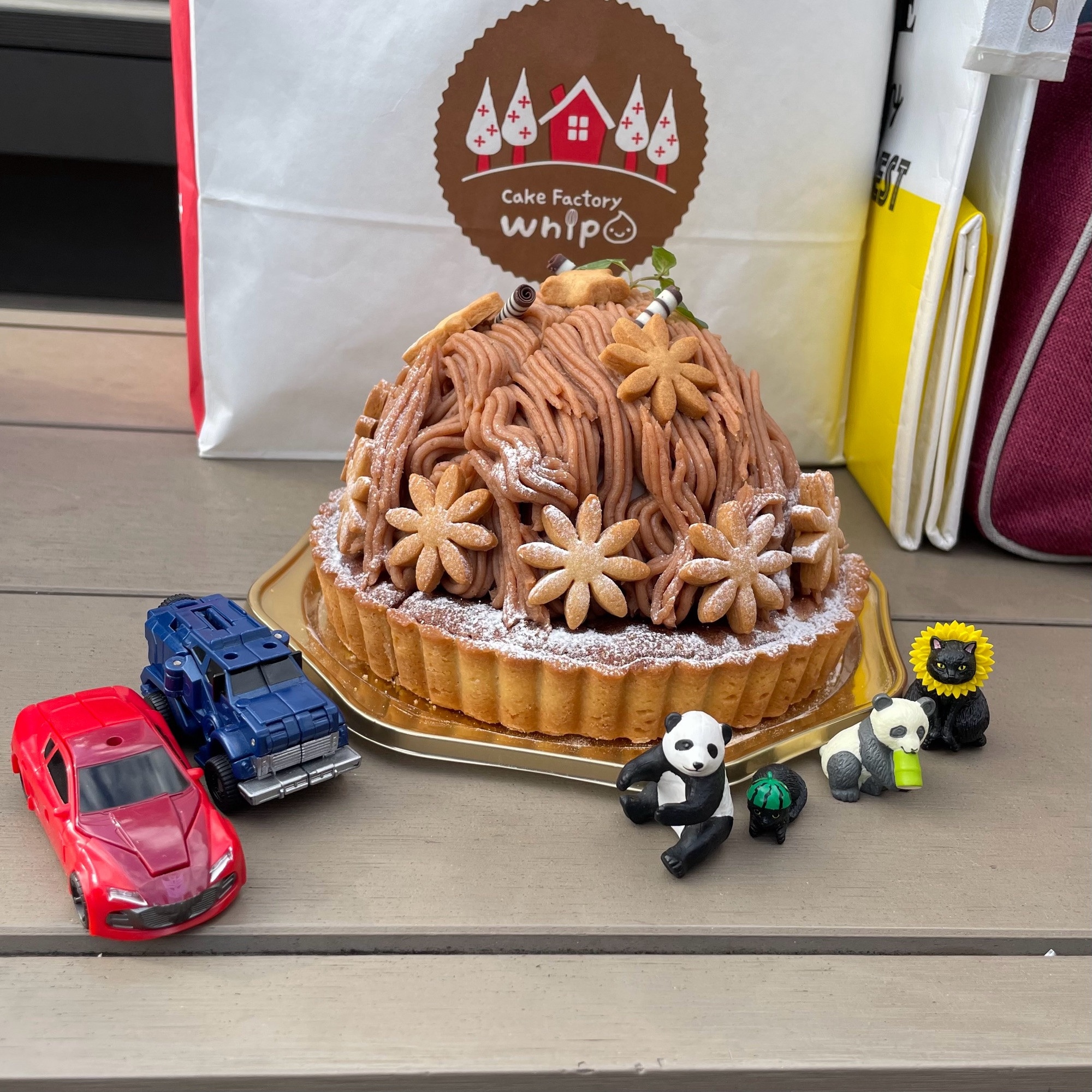 A photo of a beautiful chestnut cake made by my friend, with my Knock Out and Breakdown toys and my friend's animal toys around it
私の友達が作った美しいモンブランとそれを囲む私のノックアウトとブレークダウンの玩具と友達の動物の玩具