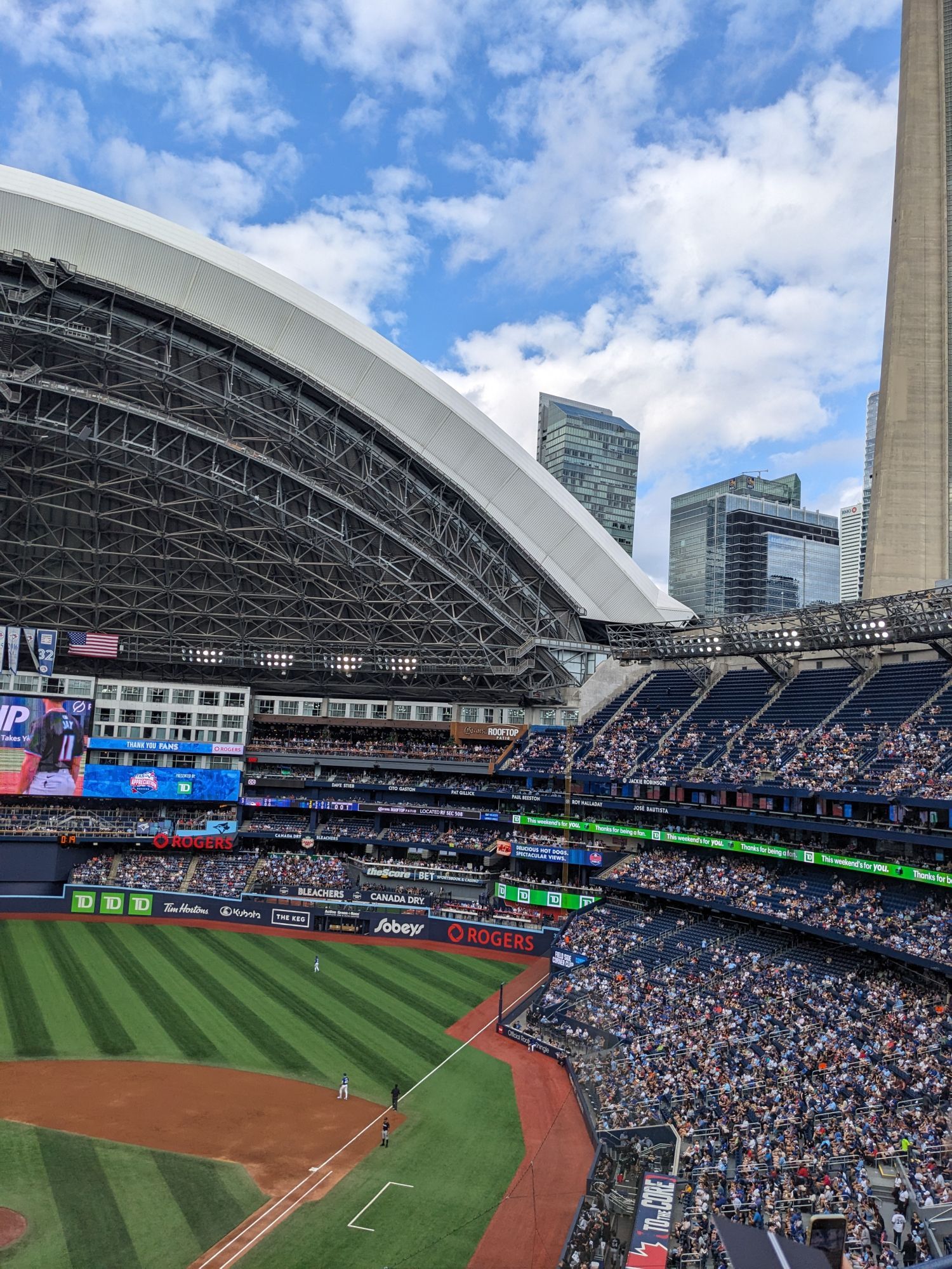 View of the open Skydome with pretty full stands, and the CN Tower above