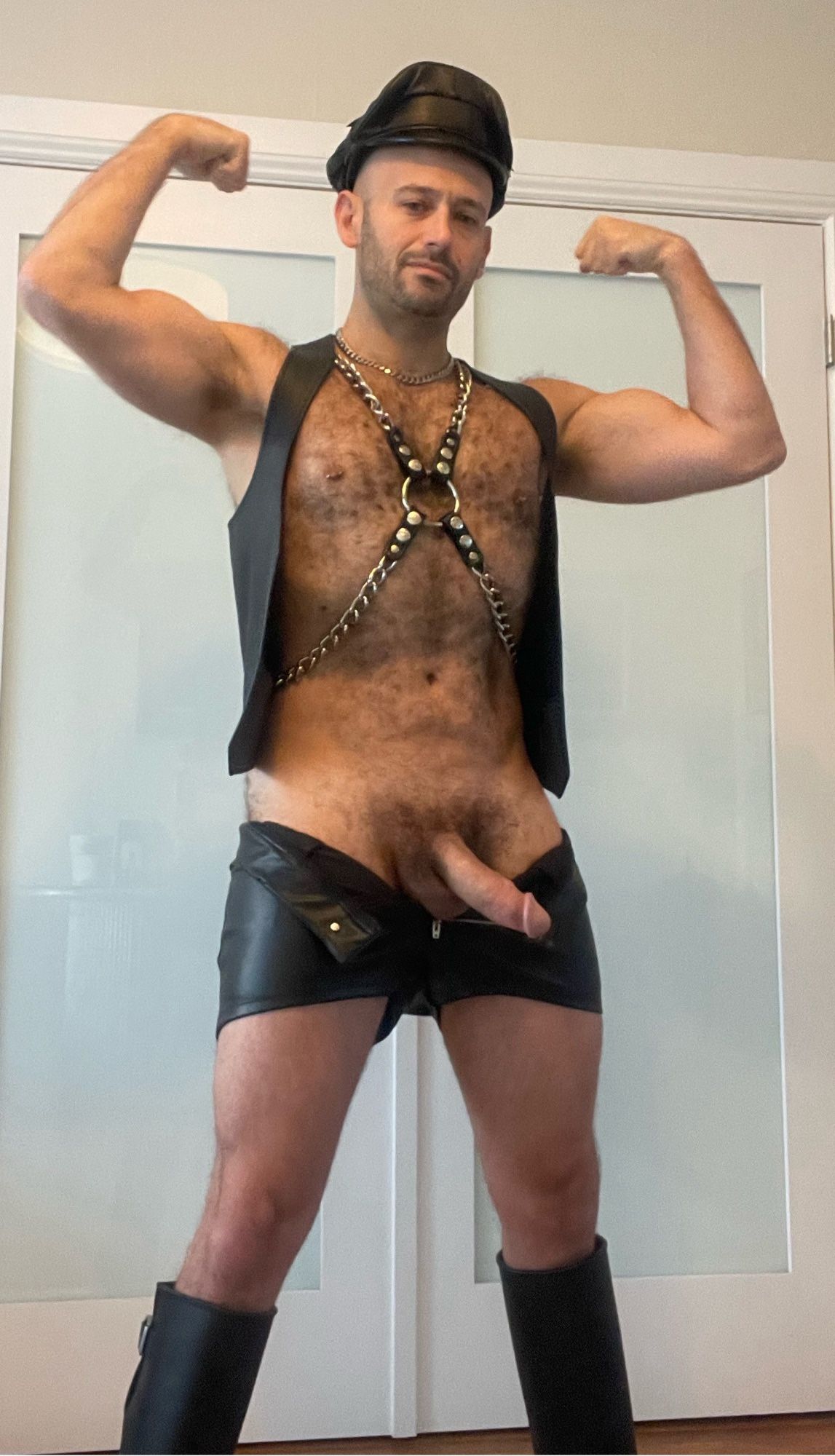 Hairy muscle otter daddy flexes in black leather while showing off his cock