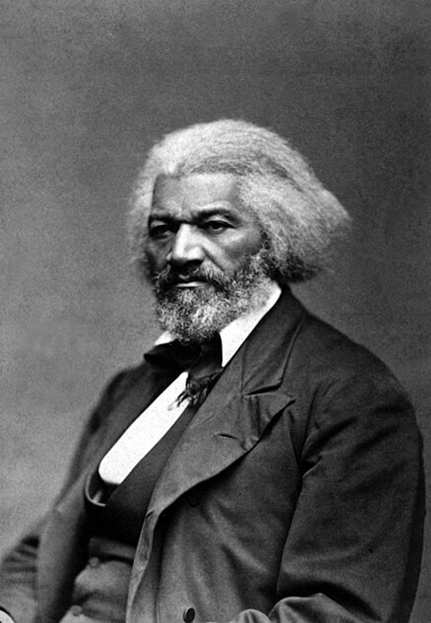 Famous black and white photograph of Fredrick Douglass with grey hair and a grey beard in 1879.