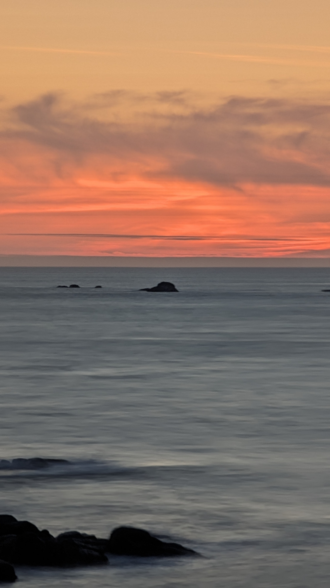 Ein Foto vom Sonnenuntergang am Meer, durch die Langzeitbelichtung wirkt das Foto als sei es mit Wasserfarben gemalt worden. Es ist alles Ingesamt sehr smooth und ruhig.