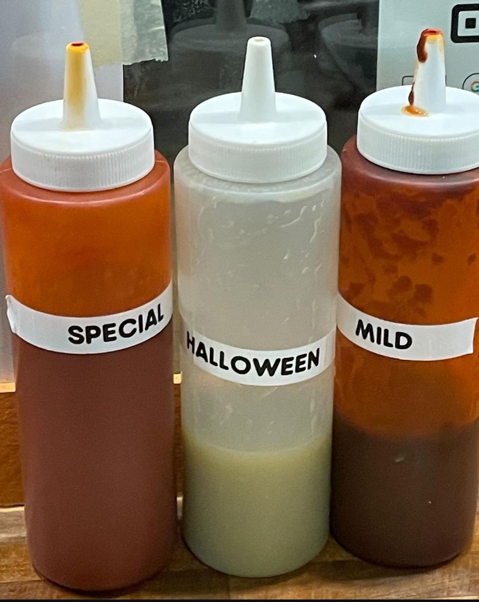 three squeeze bottles of sauce labeled 
special, Halloween & Mild