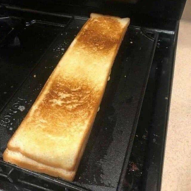 a very long grilled cheese sandwitch on a griddle 