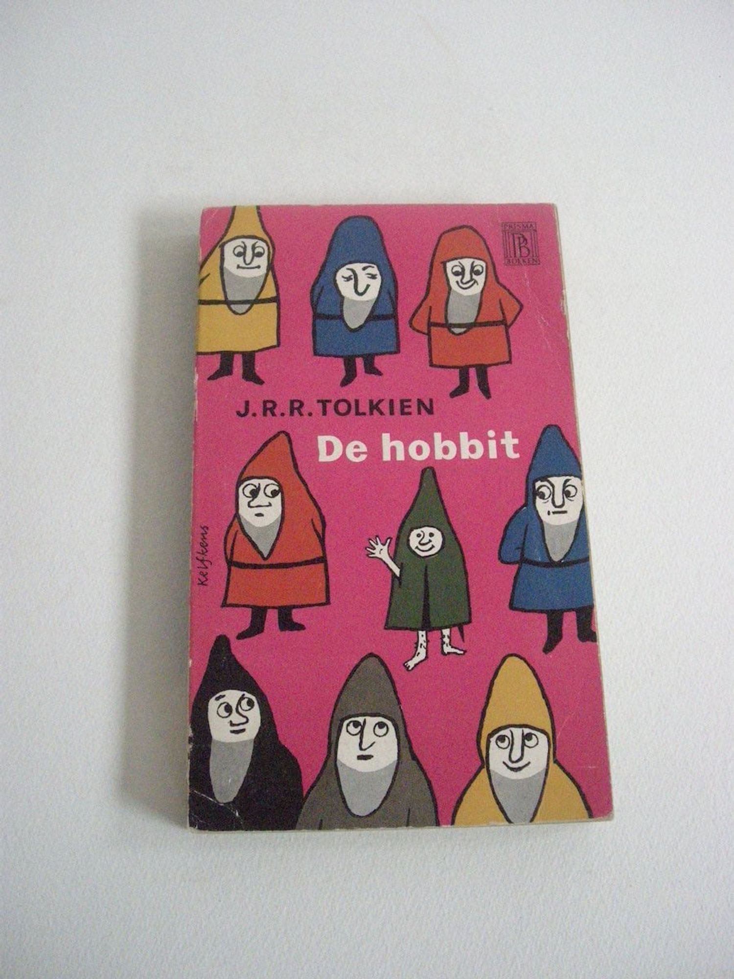 cover for a foreign editon of 'The Hobbit' showing a group of dwarves surrounding a hobbit giving it a side-eye while the hobbit smiles and waves