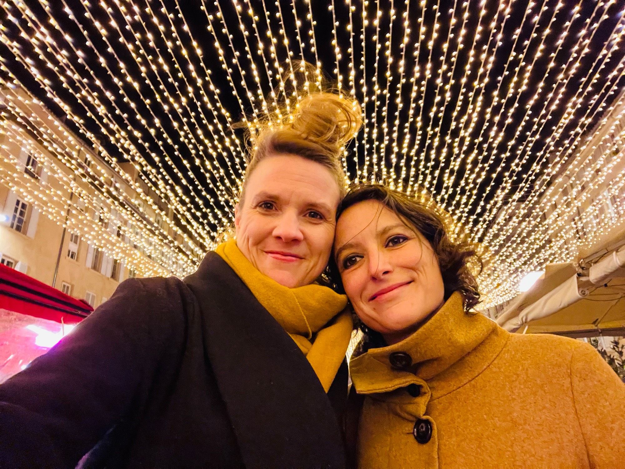 Terry and Mel in front of chains of lights in the port of Marseille.