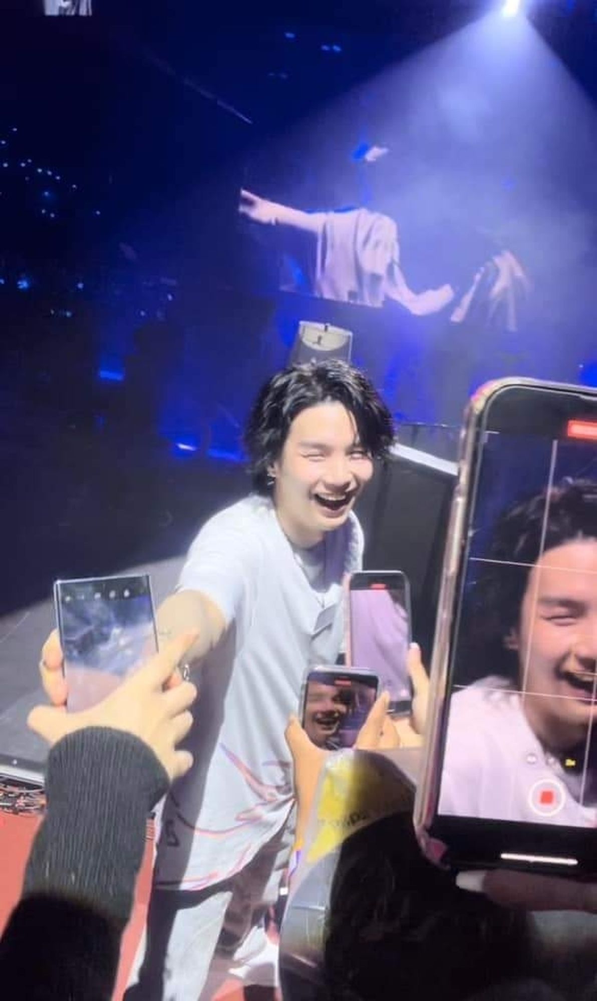 Yoongi during a D-Day concert, in this photo you can see several phones pointed at him, to take his pictures (understandable enough, he's smiling so pretty and big)