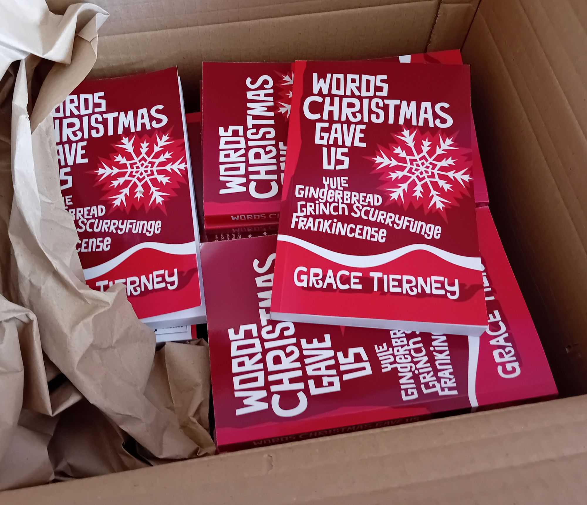 cardboard box full of paperbacks of "Words Christmas Gave Us" by Grace Tierney