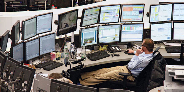 A guy looking at like 23 different computer monitors 