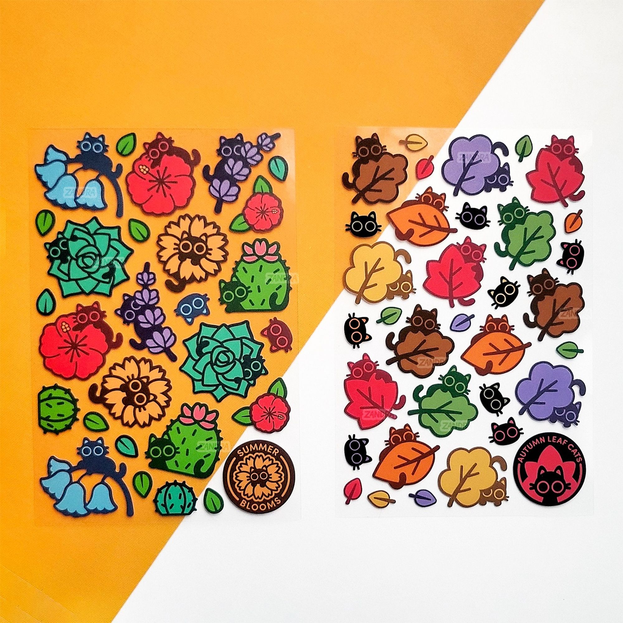 A photo of two clear sticker sheets side-by-side on an orange and white backdrop. Each sticker sheet features colorful kitties hiding behind various plants and fall leaves.