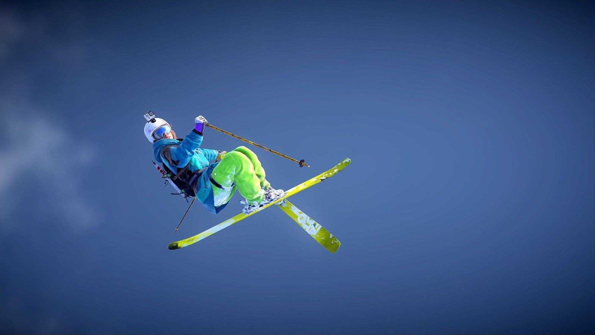 A female freerider skier holding a tail grab with behind the blue sky.