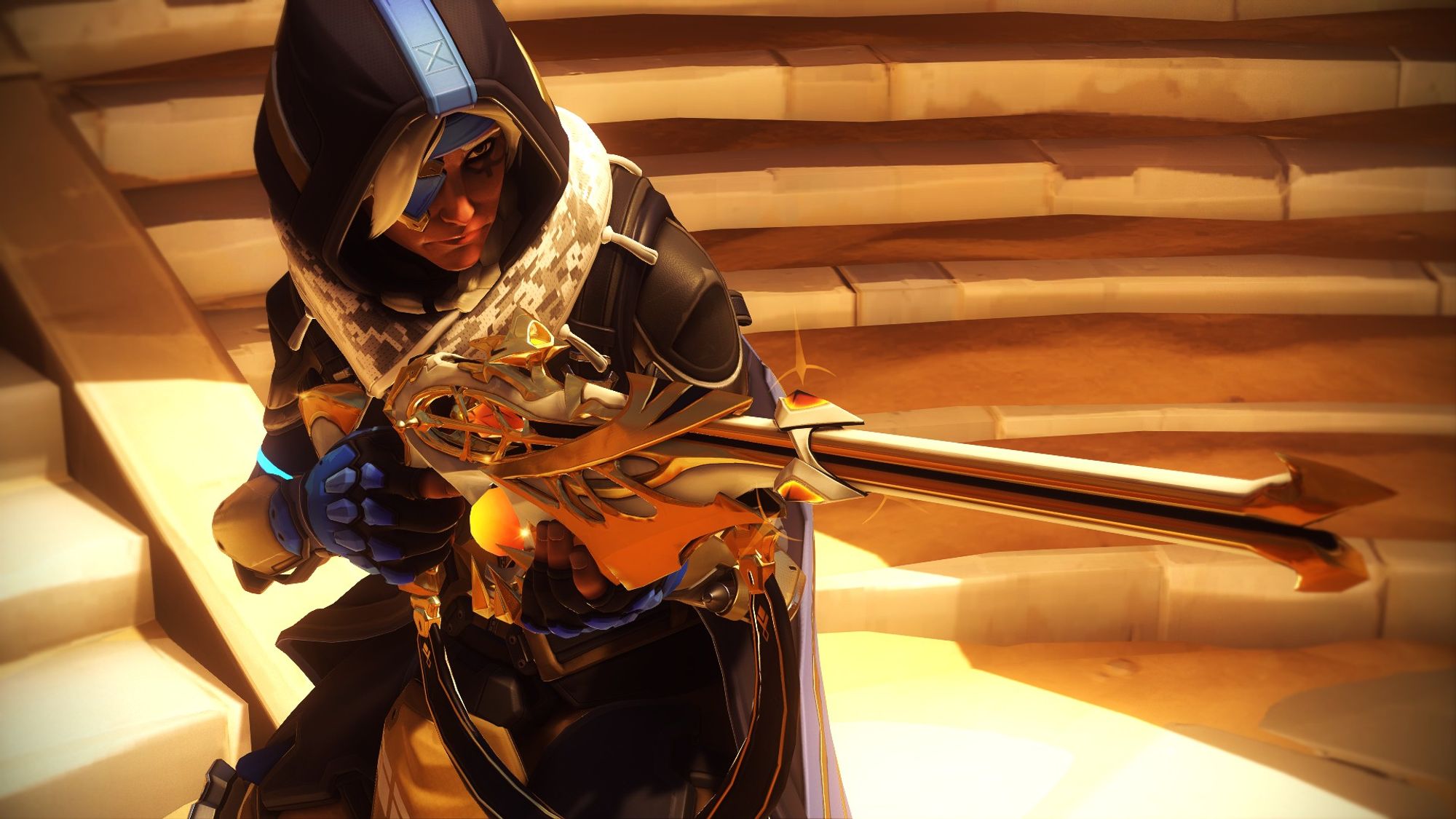 Overwatch 2 screenshot of Ana in her basic Overwatch 2 outfit. It is a tactical suit with a long blue duster with hood, a scarf that looks similar to a keffiyeh, an eye patch and a hijab under her hood. Her suit underneath is beige. She has a very ornate white and gold-detailed sniper rifle with crystal details. The shot is slightly at an angle to her right side, with her gun out and a stern look on her face.