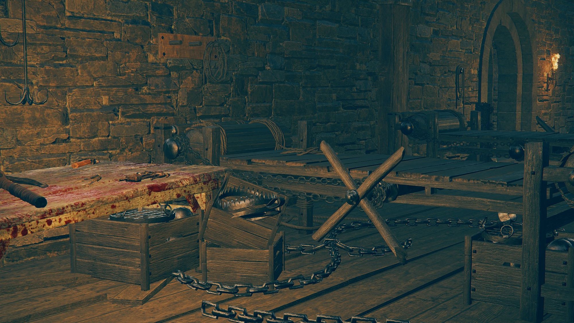 Elden Ring: Shadow of the Erdtree DLC screenshot; a dark, interior room of a fort that has a bloodied table with torture instruments and several stretching racks, chains strewn beneath them.