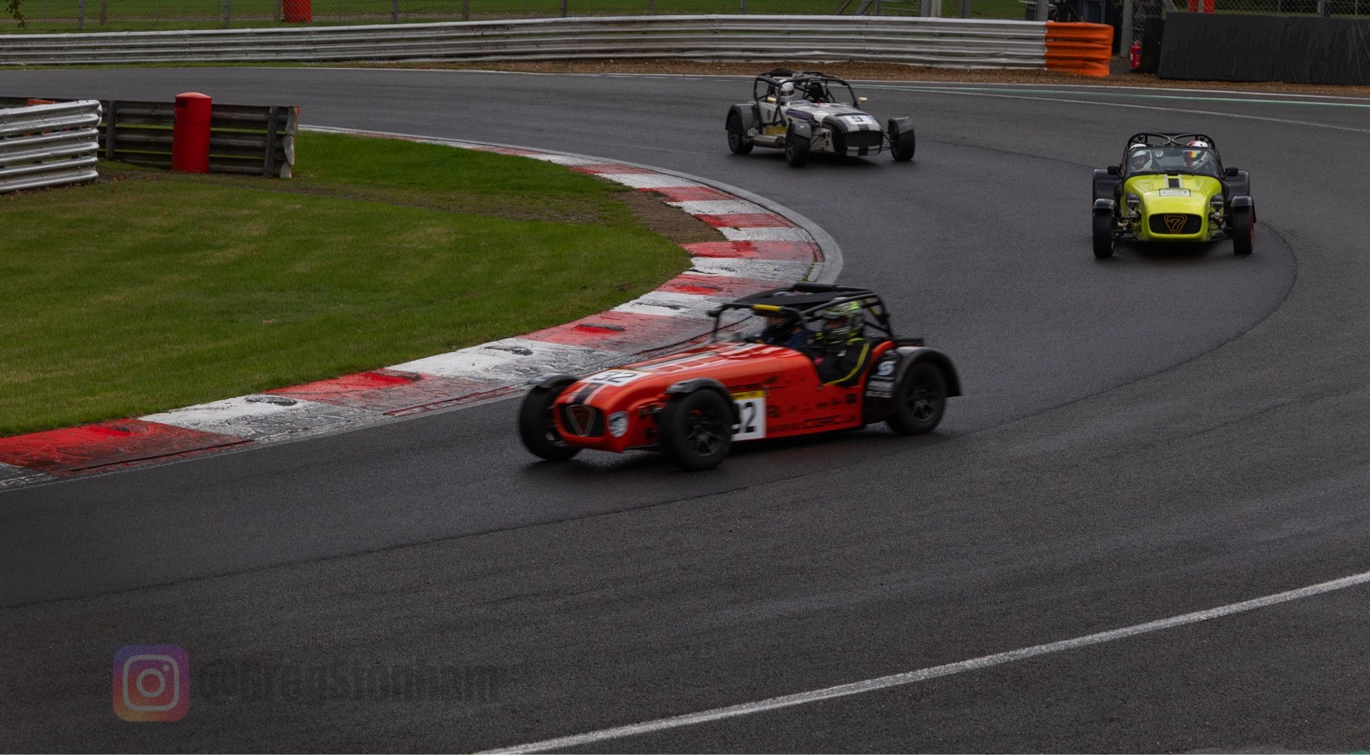 3 Caterham cars negotiating Druids Corner, Brands Hatch.