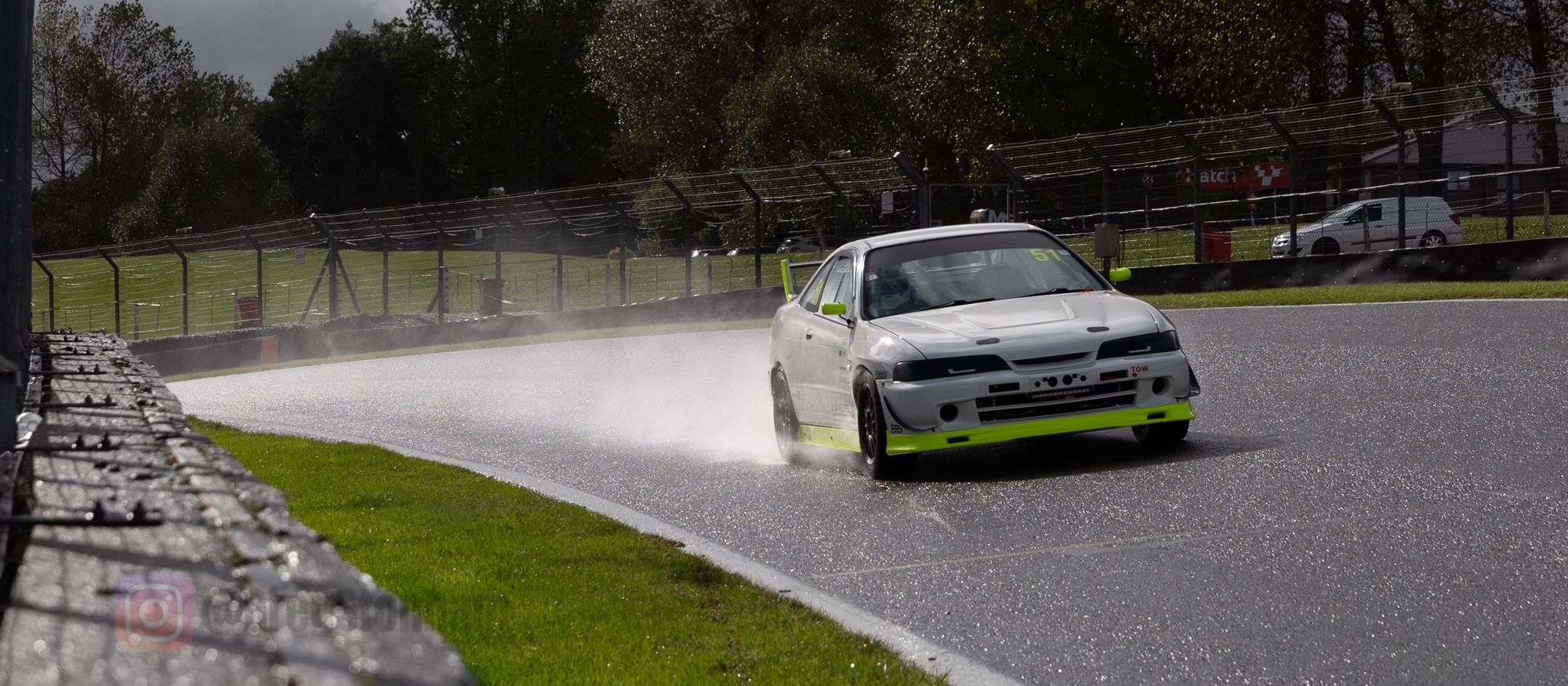 A Honda Integra DC2 (I think), Brabham Straight, Brands Hatch. The speed of the car is throwing a contrail of water behind it.