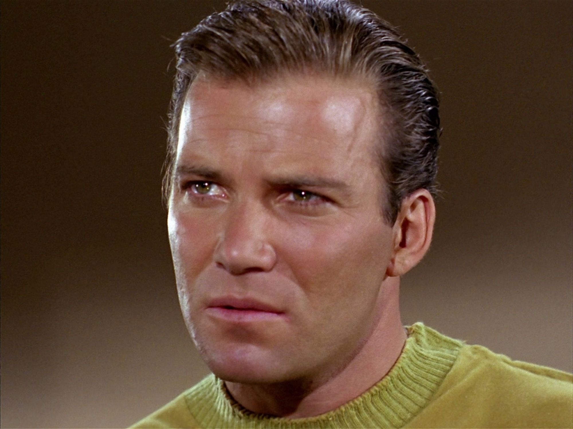 Shatner as Kirk with slicked, oiled hair.