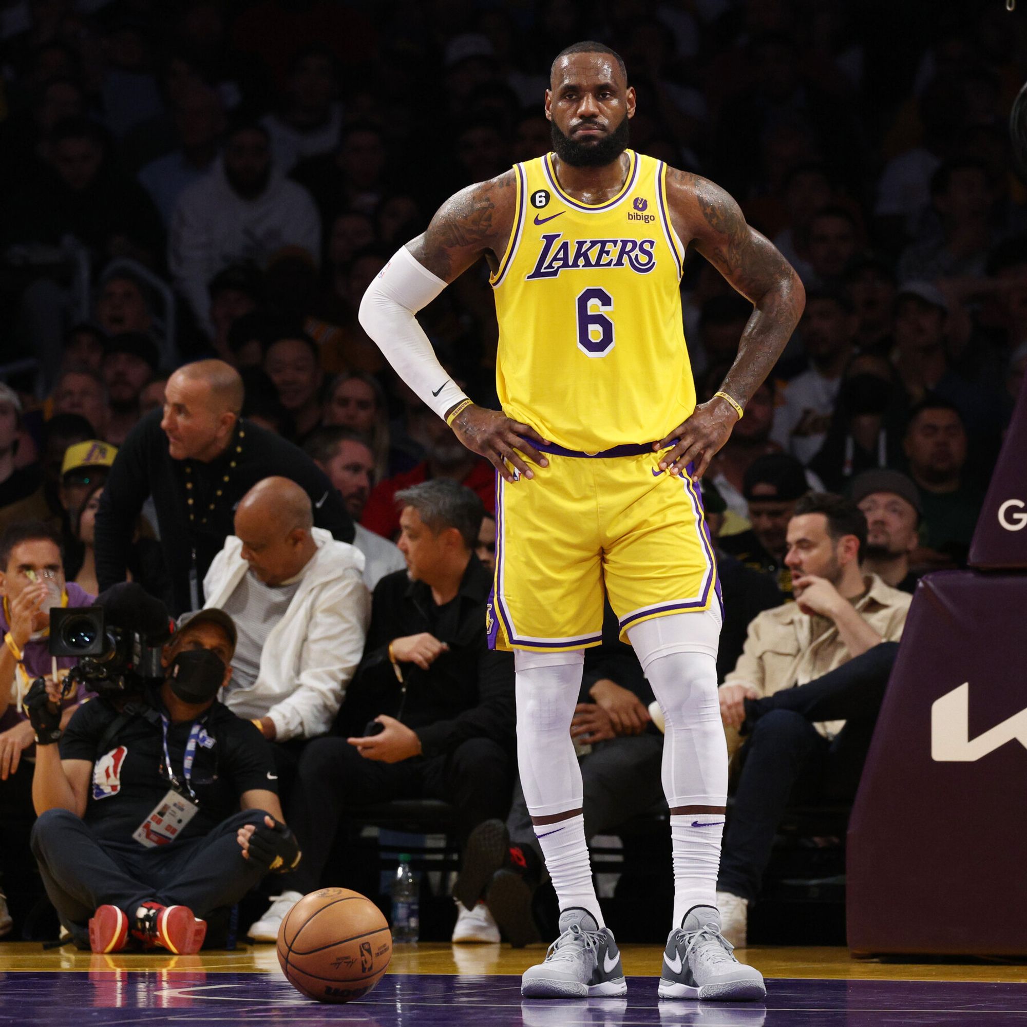 a basketball player standing on a court with a crowd watching