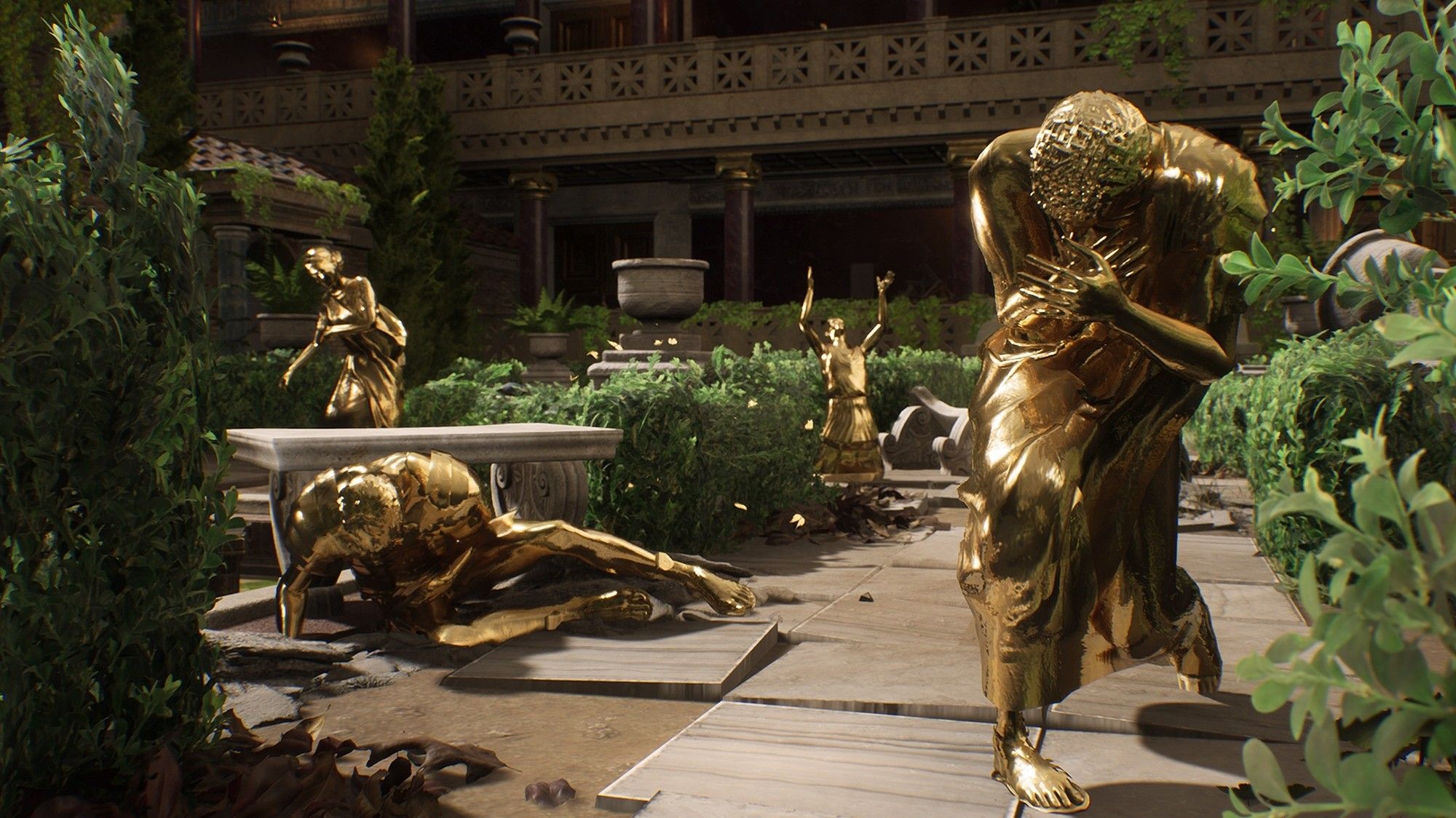 An ornate garden hosting a number of pained looking human statues made of gold.