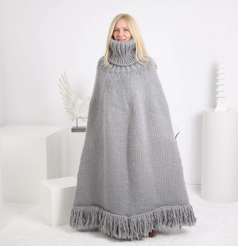 basically it's a floor-length wool pancho that starts with an oversized cable-knit turtle neck and ends with an 8 inch yarn fringe. it's hard to overstate how dope it looks