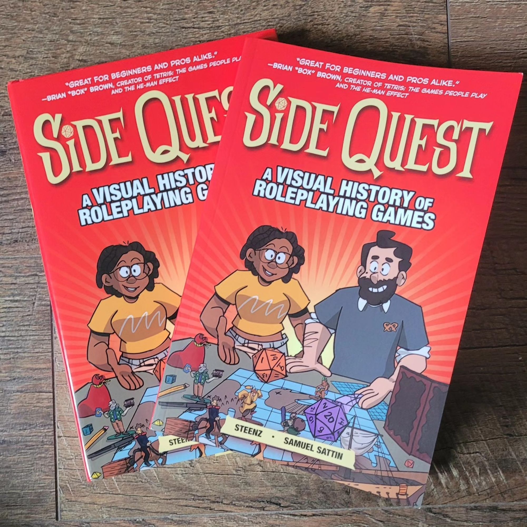 A photo of the hardcover and softcover editions of Side Quest: A Visual History of Roleplaying Games