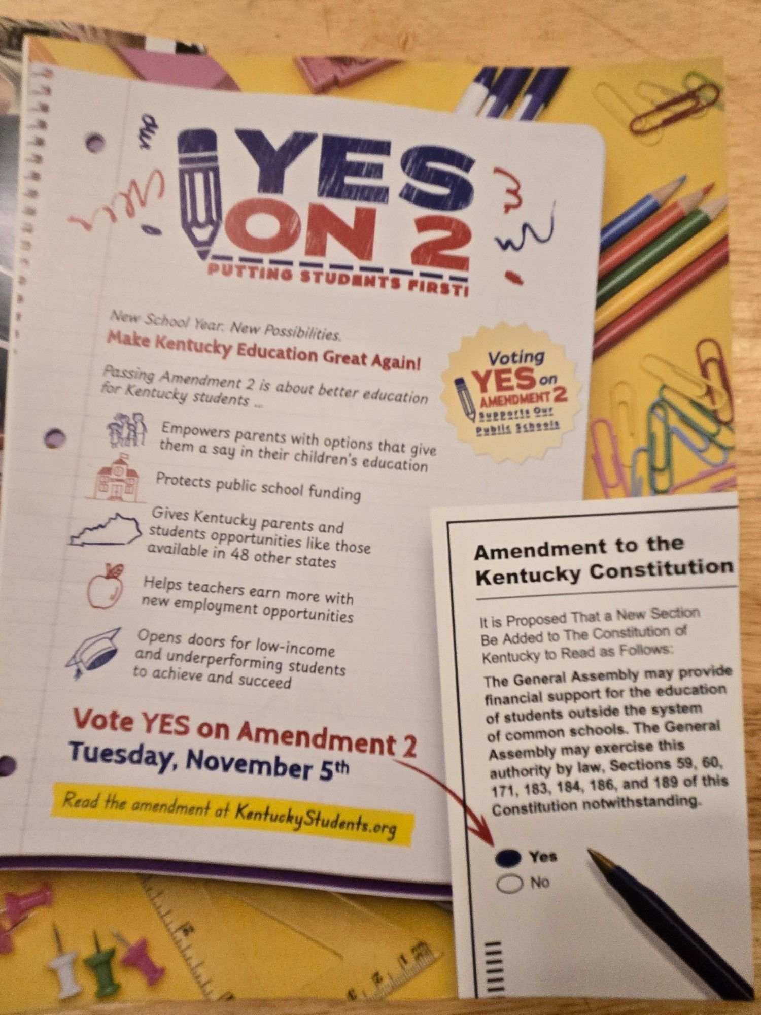 Picture Two Side One: Image two sheets of paper on a table with office supplies and stuff. First paper reads
**
YES
ON 2
PUTTING STUDENTS FIRST!
New School Year. New Possibilities
Make Kentucky Education Great Again!
Passing Amendment 2 is about better education
for Kentucky students ...
Empowers(sic) parents with options that give
them a say in their children's education
Protects public school funding 
Gives Kentucky parents and
students opportunities like those
available in 48 other states
Helps teachers earn more with
new employment opportunities
Opens doors for low-income
and underperforming students
to achieve and succeed
Vote YES on Amendment 2
Tue, Nov 5th
Read the amendment at KentuckyStudents.org
**
The other paper is of the amendment I'll do a photo with its text as this is running long as well and I wanted to mention why this was included. It is from the same people as the other mailer that suggested VP Harris approved the Amendment, she doesn't. Its vouchers (spolier) 🤭