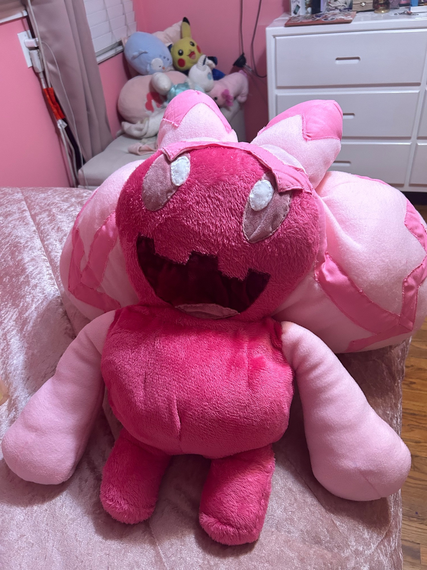 A large work in progress plushie made to resemble the Pokémon Tinkaton from Pokémon Scarlet/Violet, She looks like she has a large toothy grin. She’s almost complete and only really missing her fingers and her signature hammer.