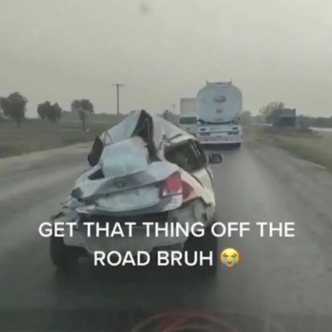a car that's been destroyed to be unrecognizable on the road with the caption: "GET THAT THING OFF THE ROAD BRUH 😭😭😭" 