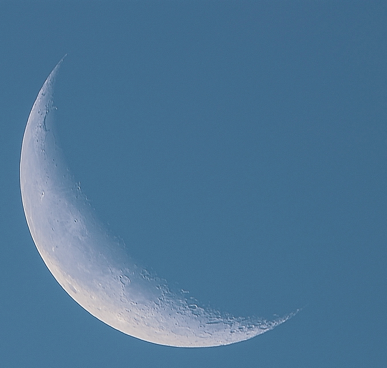 Stacked image of Crescent Moon against morning blue sky