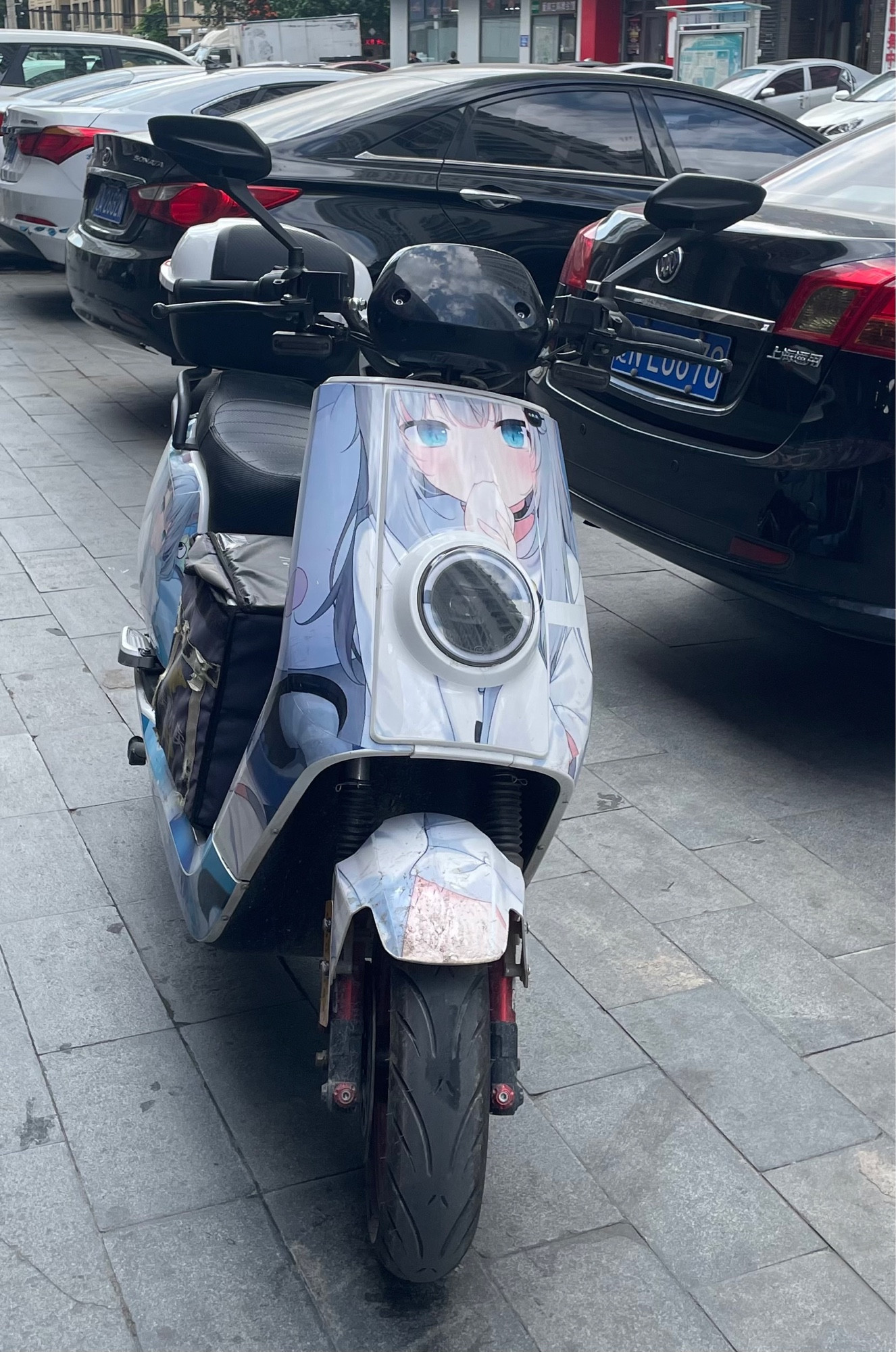 Worn out takeout delivery electric bike with anime girl paintings.