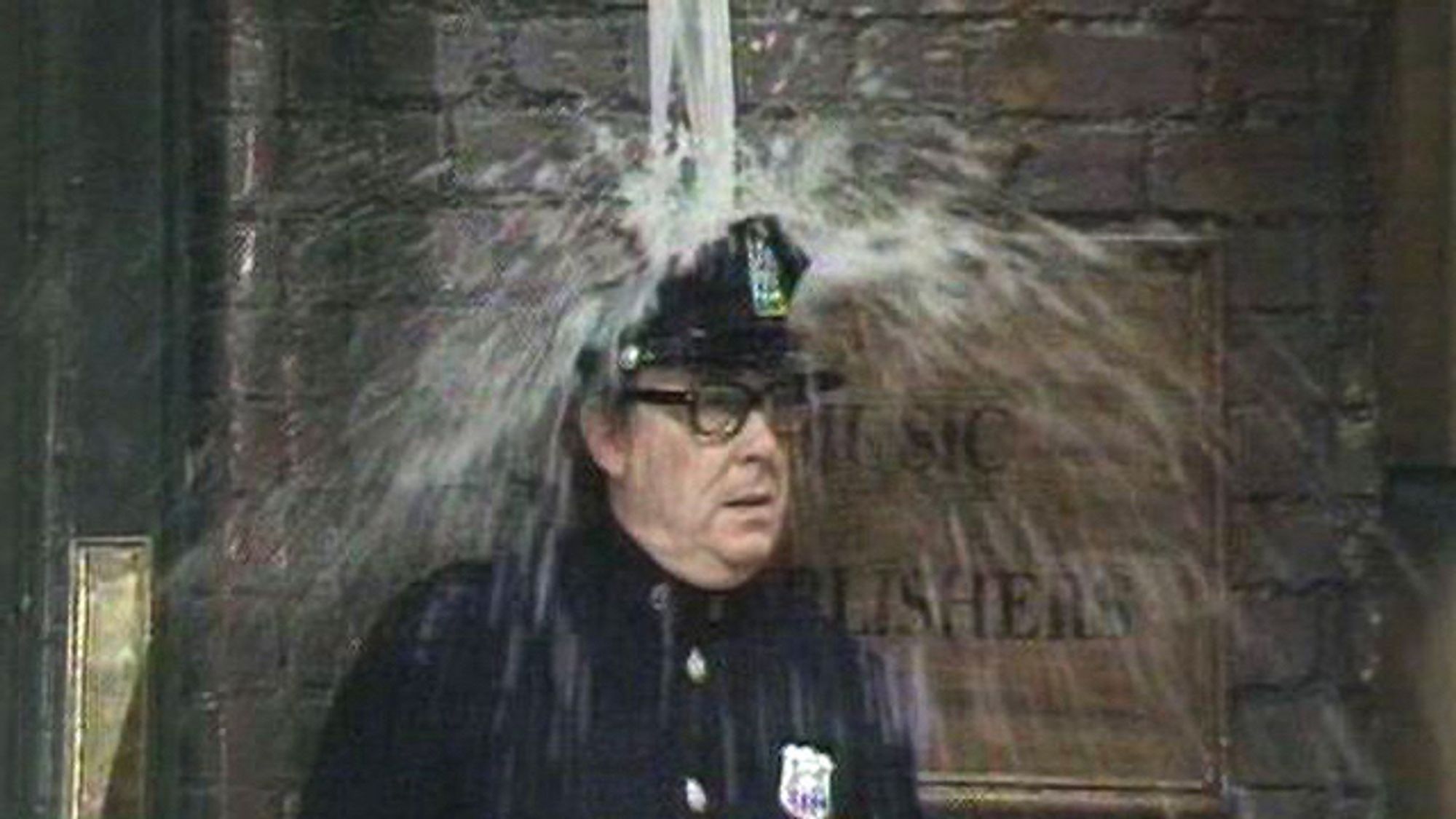 Eric Morecambe in the ‘Singing in the rain’ sketch. Water pouring down over his head.