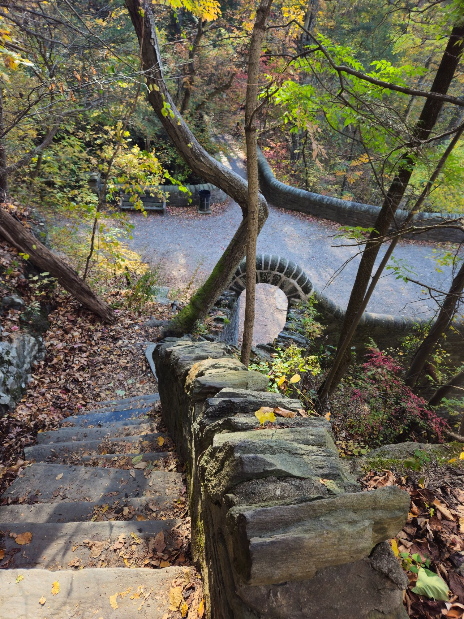 Old stone stairs leading to a stone arch that  let's out onto a trail.