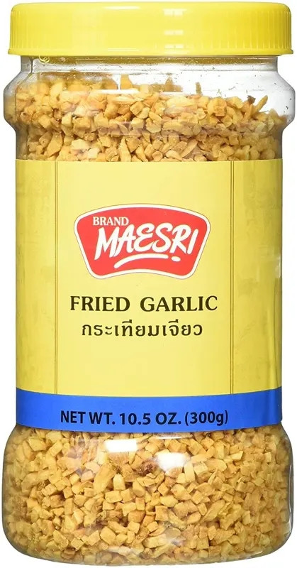 a jar of maesri brand fried garlic. the jar has a yellow label and lid with blue and red printing. the contents like almost like ground peanuts size shape & color