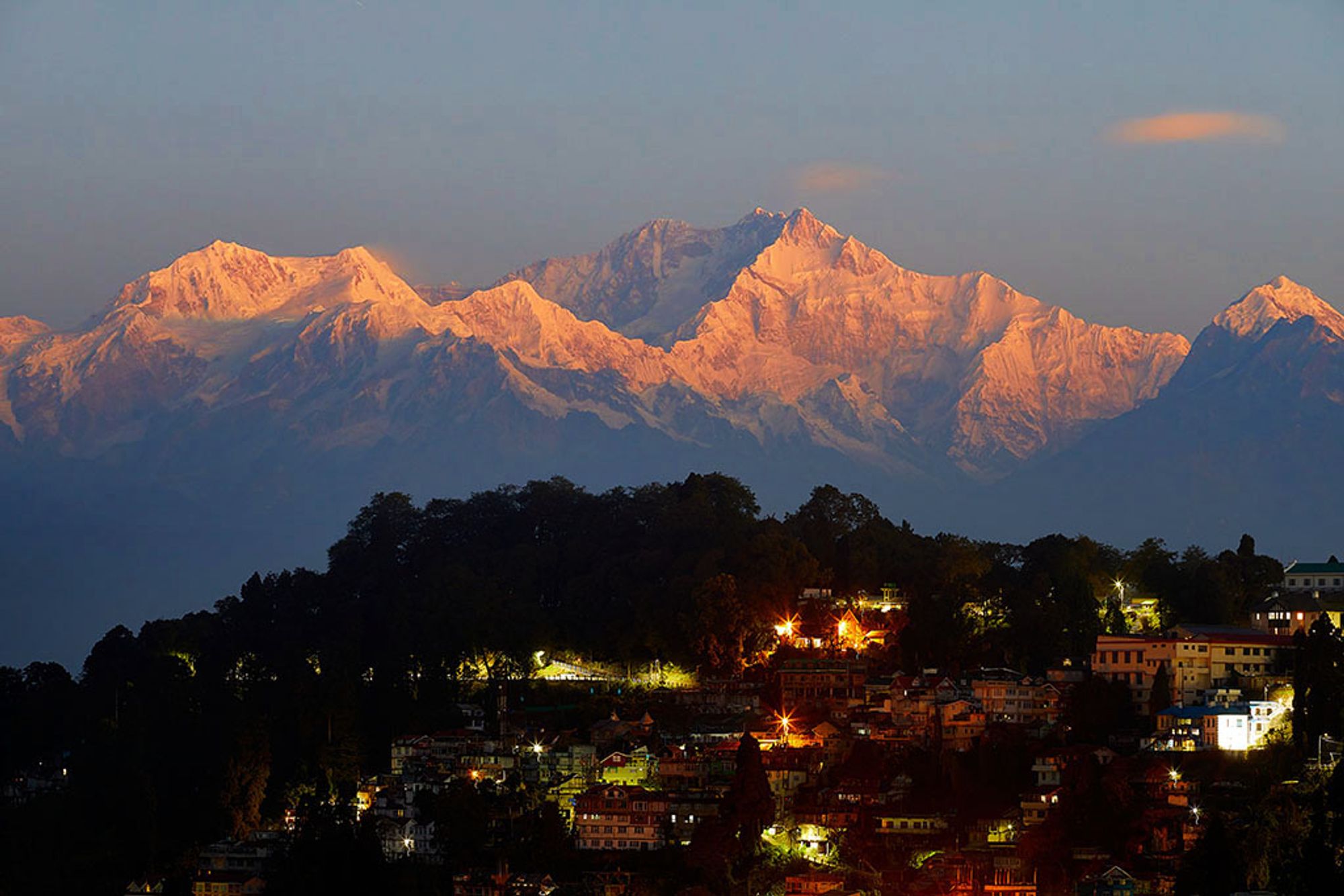 Mt Kanchenjunga, the third highest mountain on the world at 8,586 metres, catches the first rays of dawn as the town of Darjeeling wakes up