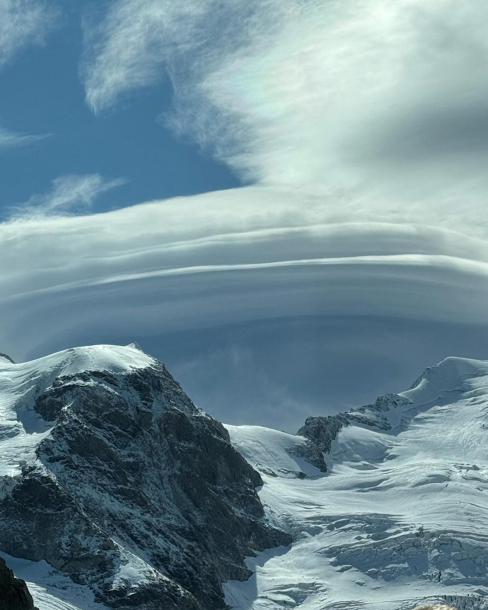 Clouds at the tops of the Alps that look like folded meringue.